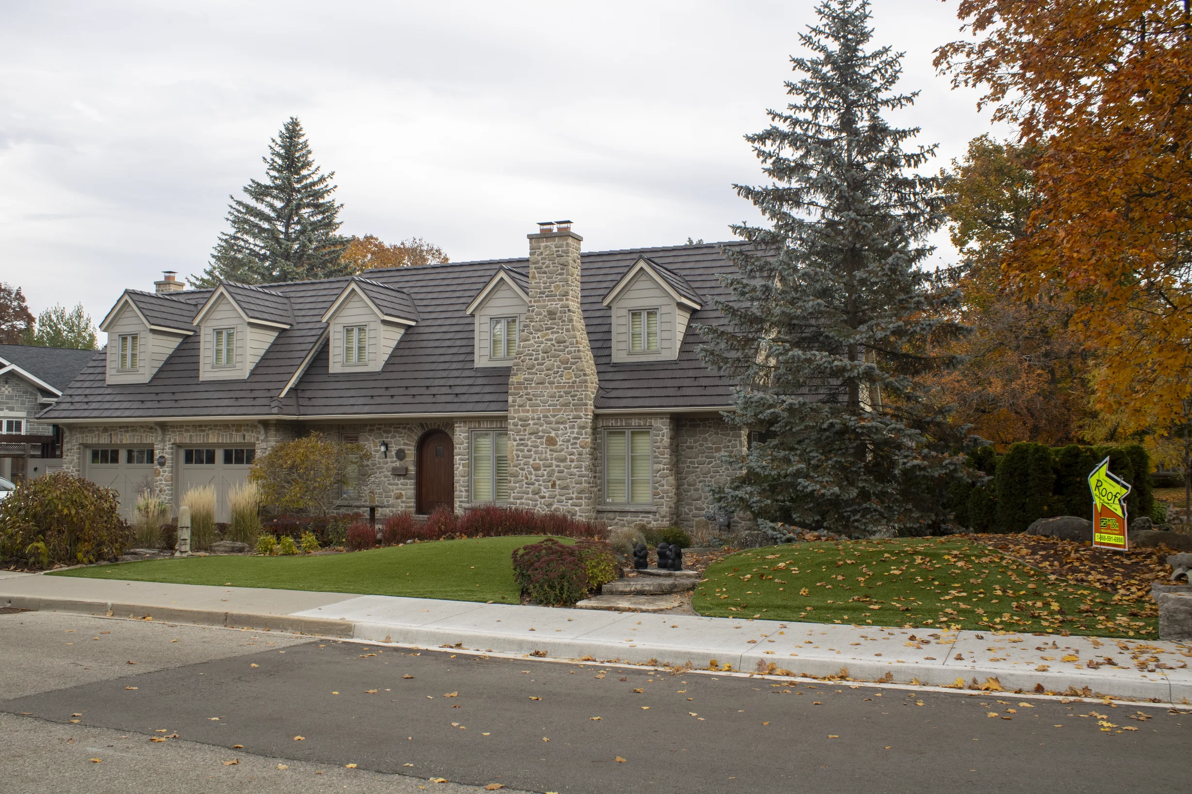 Tudor Brown Interlock Shake aluminum roof on a two-storey Tudor home with dormers and a metal roof in, Waterloo, Ontario