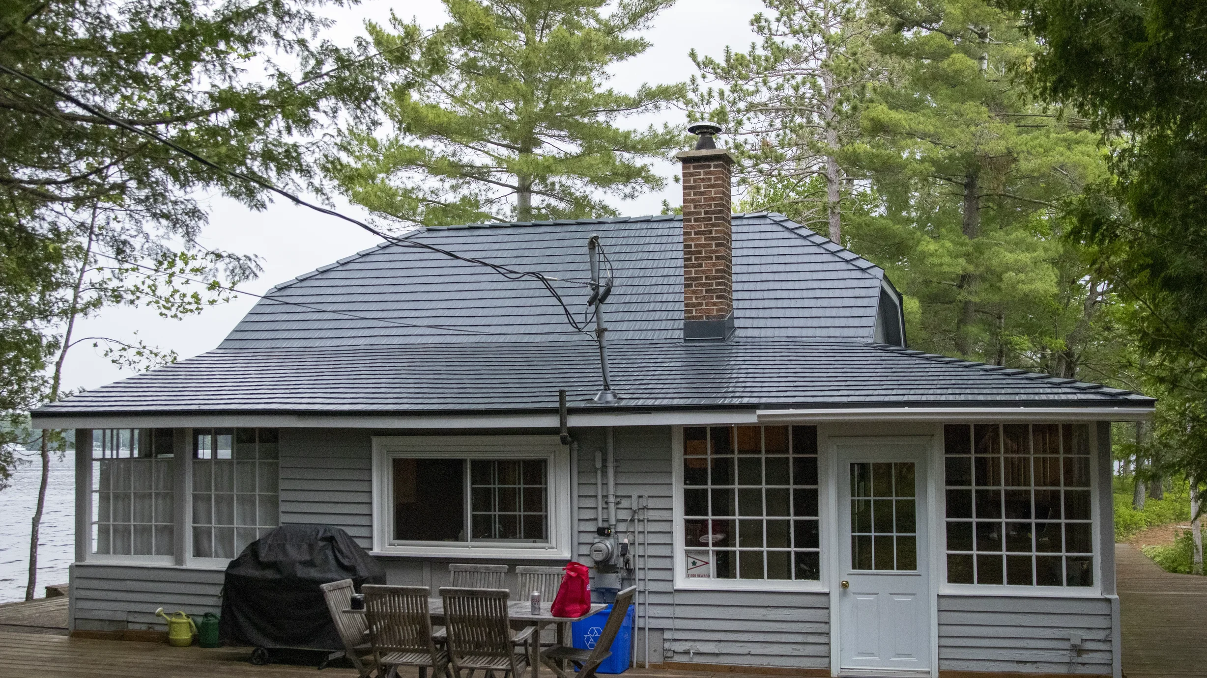 Deep Charcoal Interlock Cedar Shingle aluminum roof on a grey cottage with a metal roof on a lake surrounded by, Winderemere, Ontario