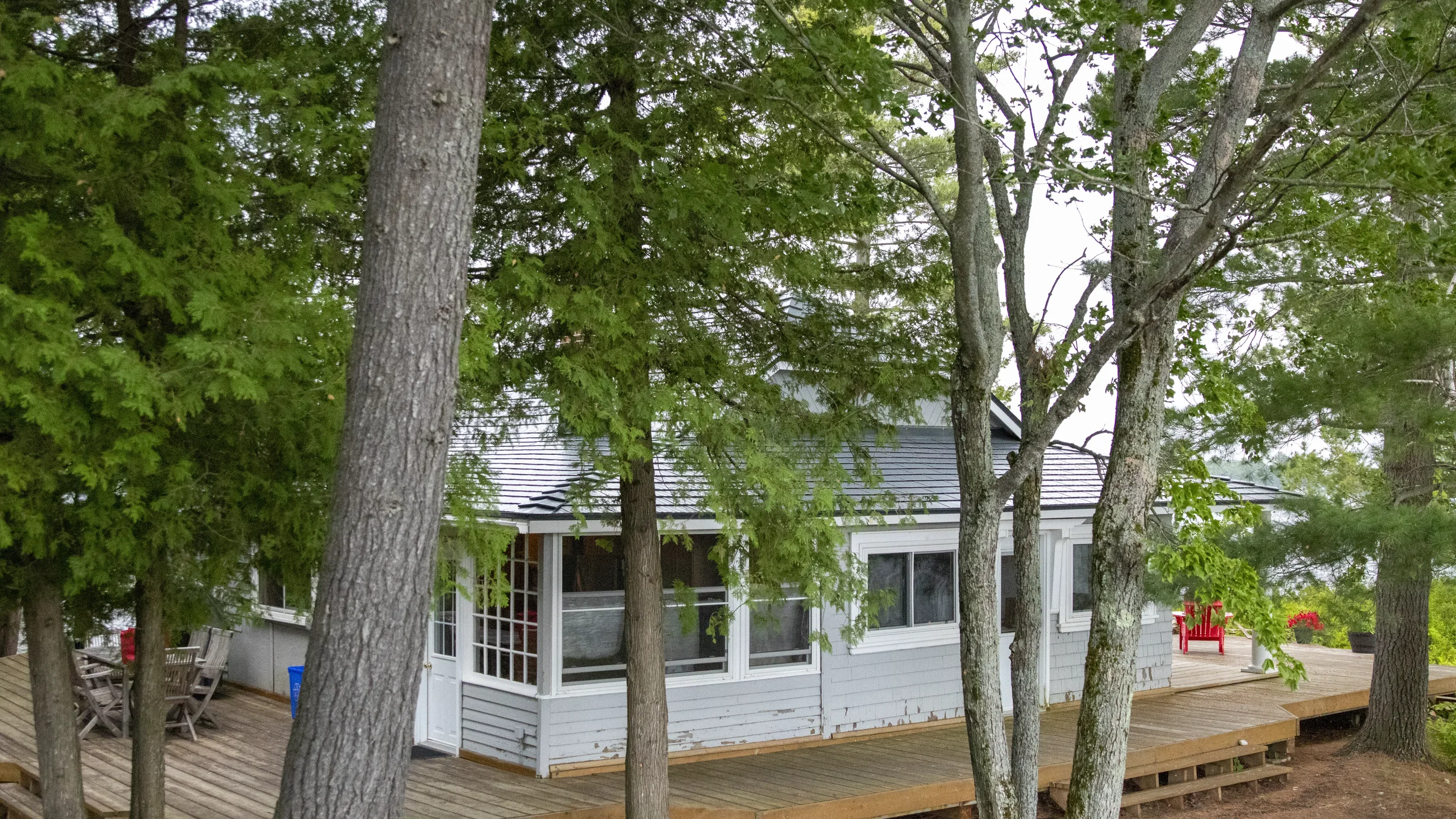 Deep Charcoal Interlock Cedar Shingle aluminum roof on a white cottage with a metal roof and a large deck, Winderemere, Ontario