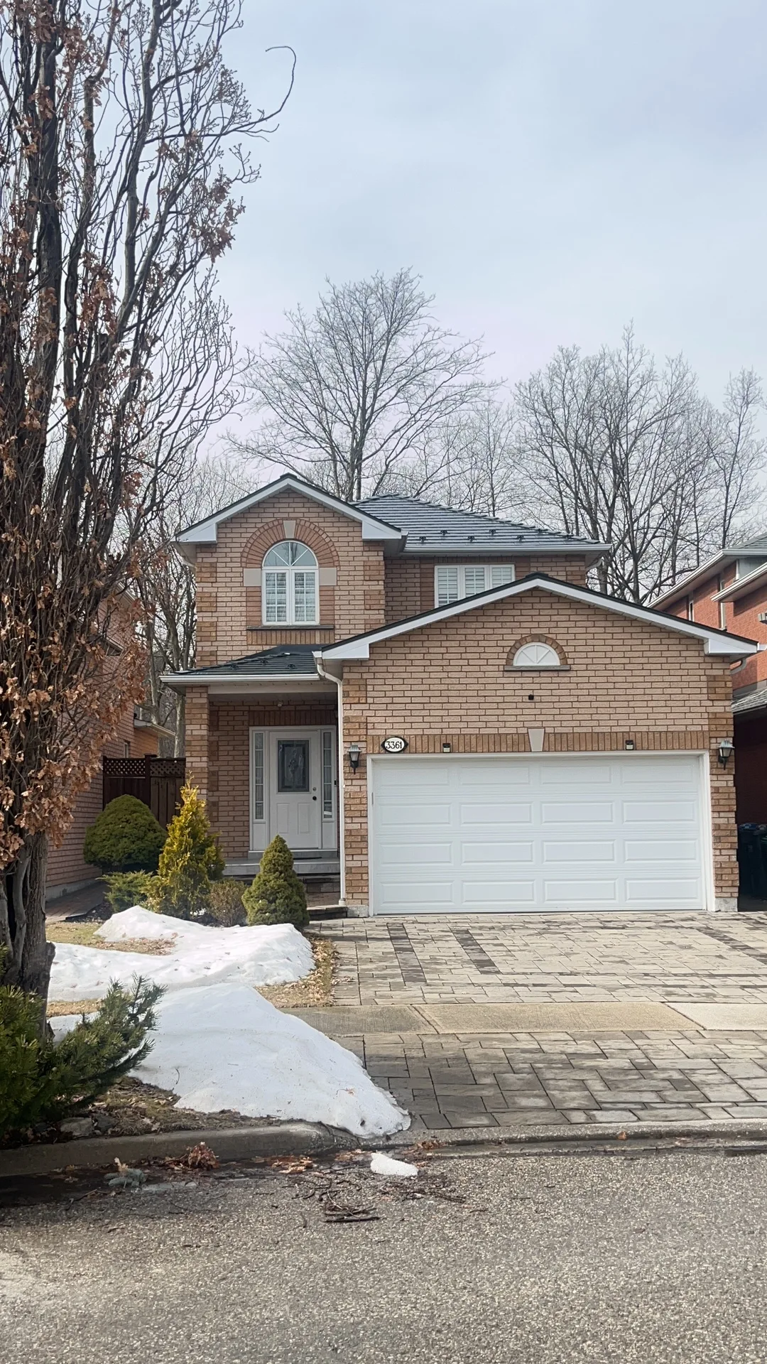 Black Interlock Slate aluminum roof on a brown brick home with a two-car garage and a paved, Mississauga, Ontario