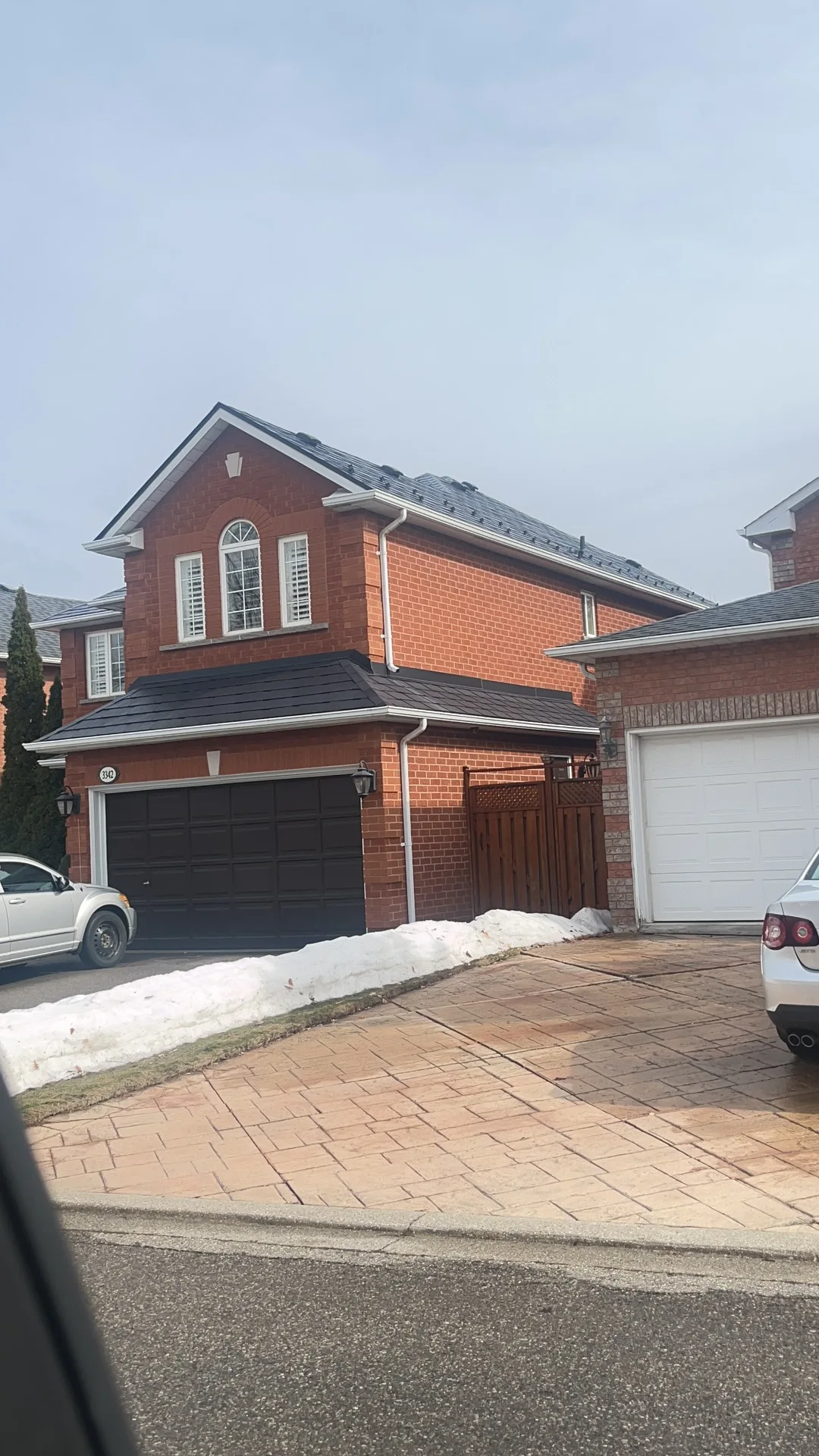 Black Interlock Slate aluminum roof on a brick house with a metal roof in a suburban area, Mississauga, Ontario