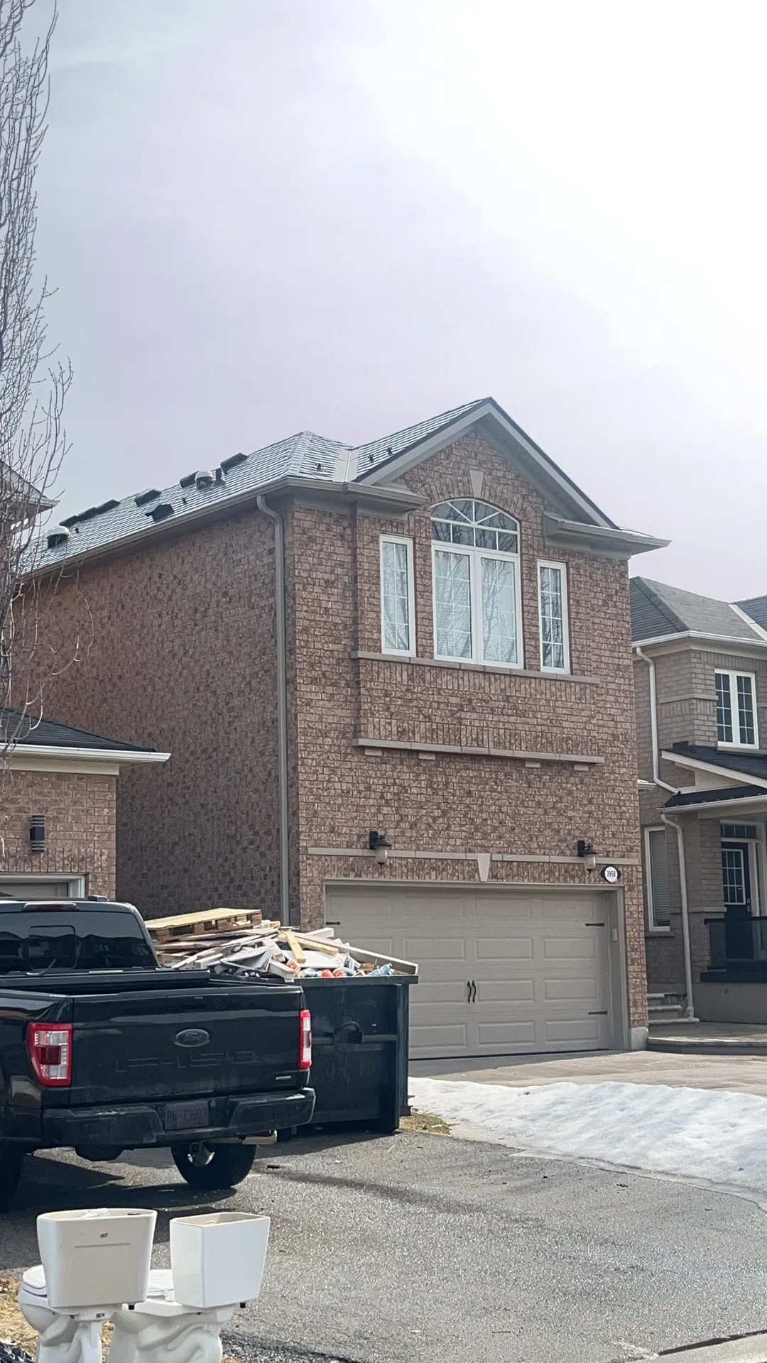 Deep Charcoal Interlock Slate aluminum roof on a brick two-storey home with dormers and a metal roof, Mississauga, Ontario