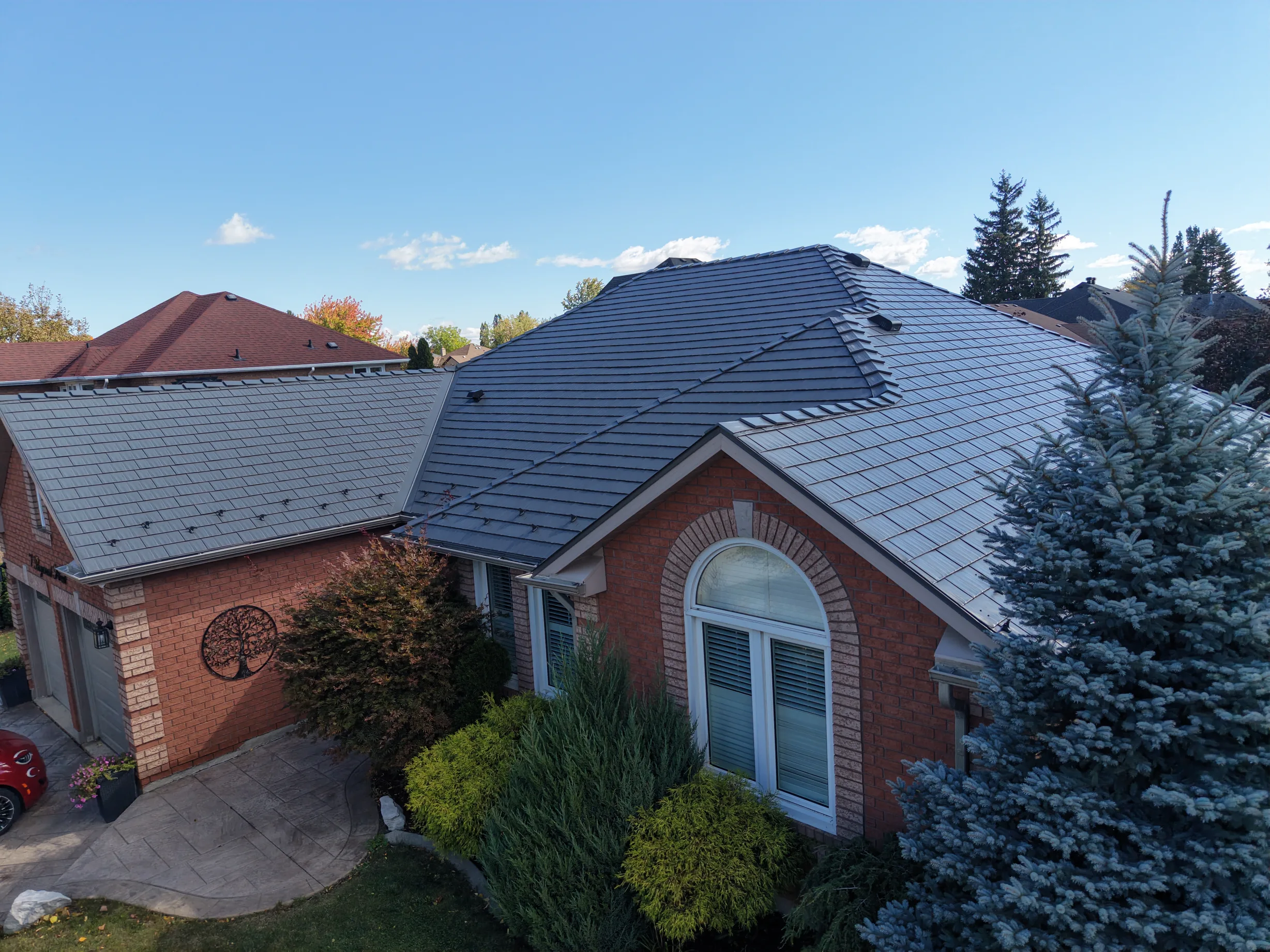 Musket Grey Interlock Cedar Shingle aluminum roof on a red brick single-family home with a metal roof in a, Brampton, Ontario