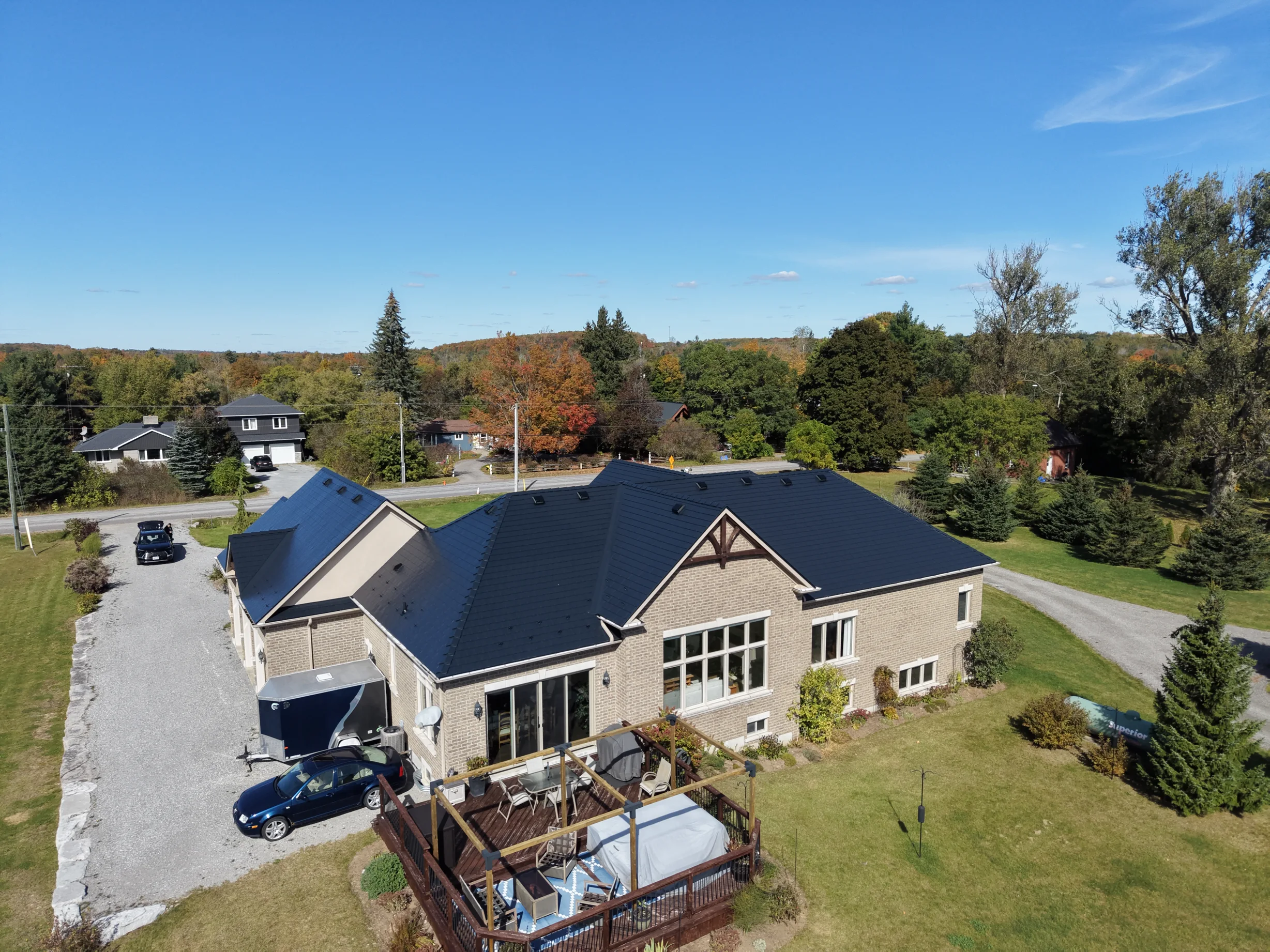 Black Interlock Slate aluminum roof on a tan home with a black metal roof in a rural setting, Blackstock, Ontario