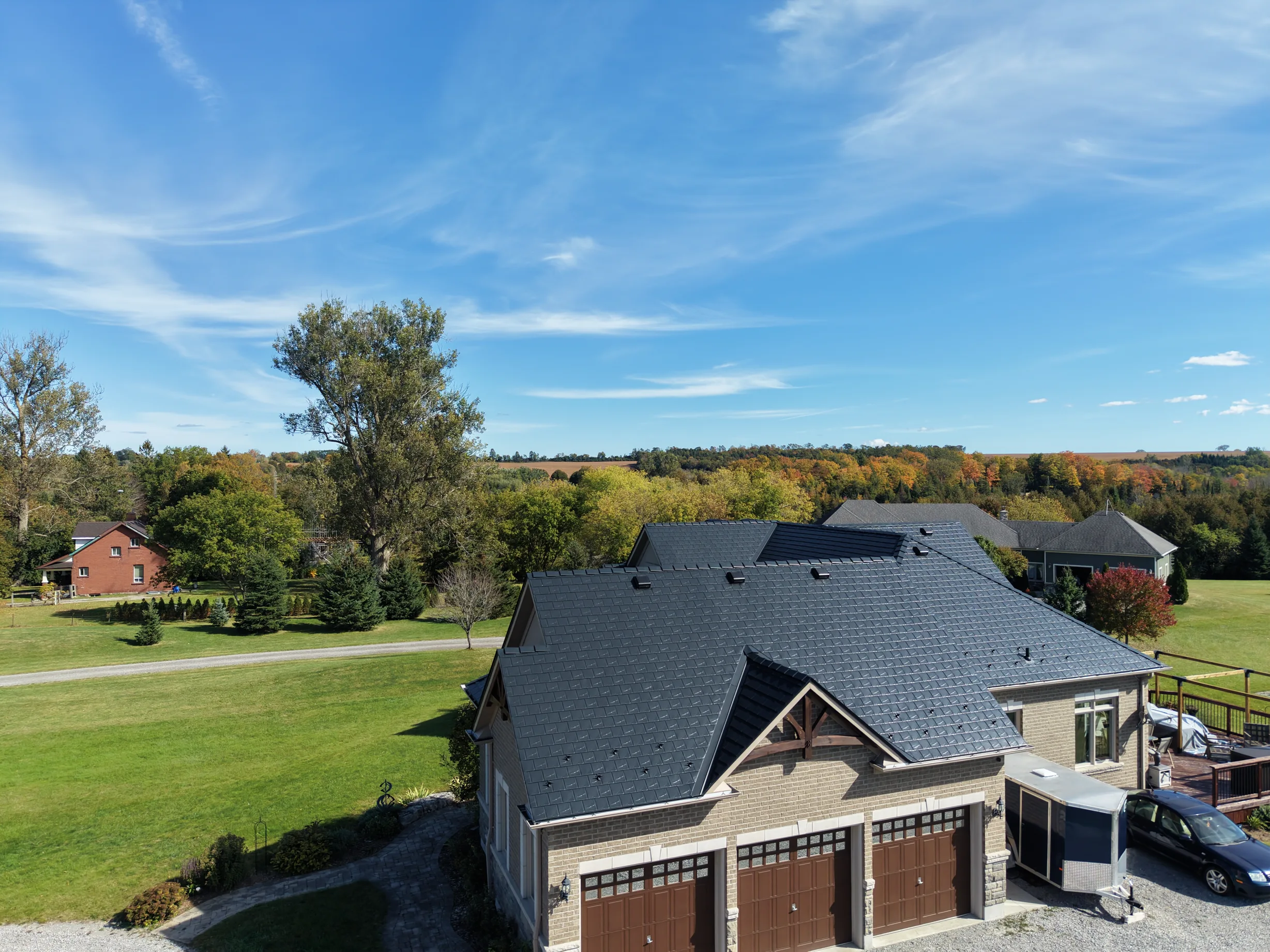 Black Interlock Slate aluminum roof on a tan ranch style home with a black metal roof in a, Blackstock, Ontario