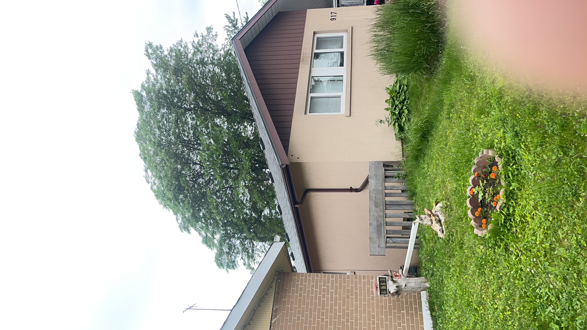 Single-storey ranch home at 917 with Interlock Musket Grey aluminum slate roofing on a simple gable, stucco exterior, Scarborough ON.