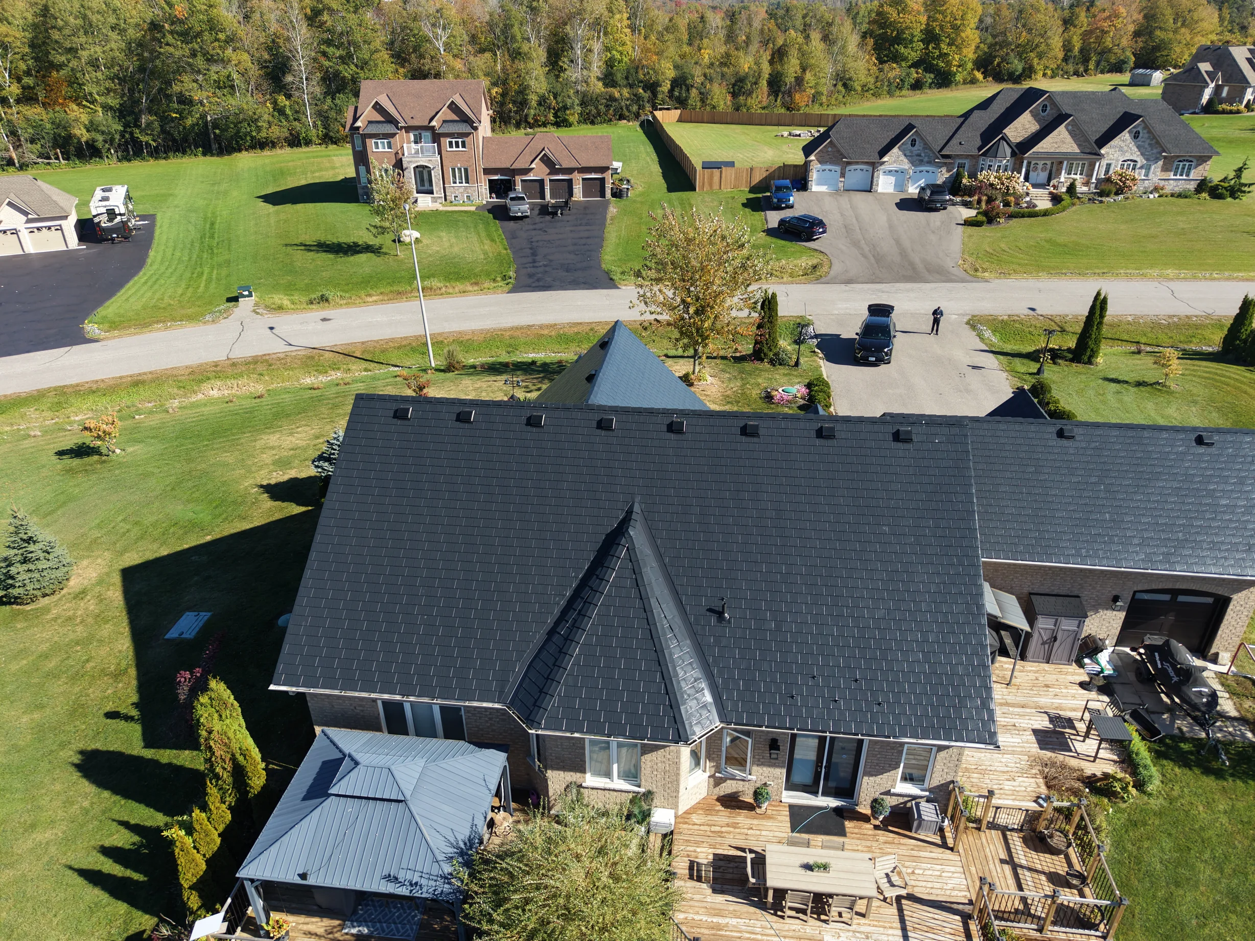 Black Interlock Slate aluminum roof on a black ranch-style home among tall trees in the Kawartha, Kawartha Lakes, Ontario