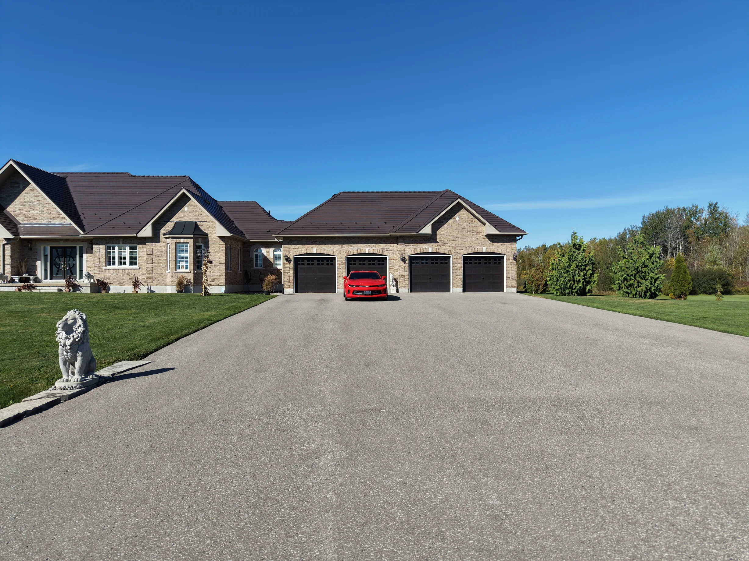 Tudor Brown Interlock Slate aluminum roof on a Tudor home with a brown metal roof in a wooded area, Kawartha Lakes, Ontario