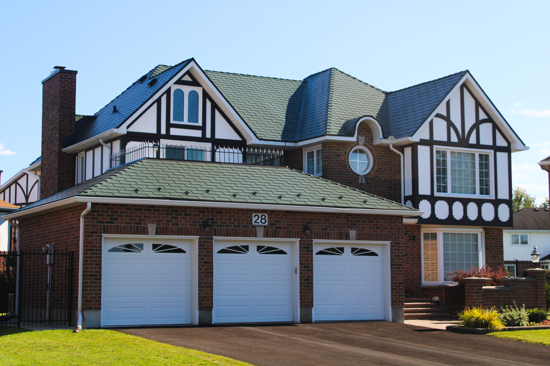 Tudor-style brick home with complex multi-hip Interlock aluminum shingle roof in Hunter Green, triple garage, dormers, and chimney in Nepean, ON.