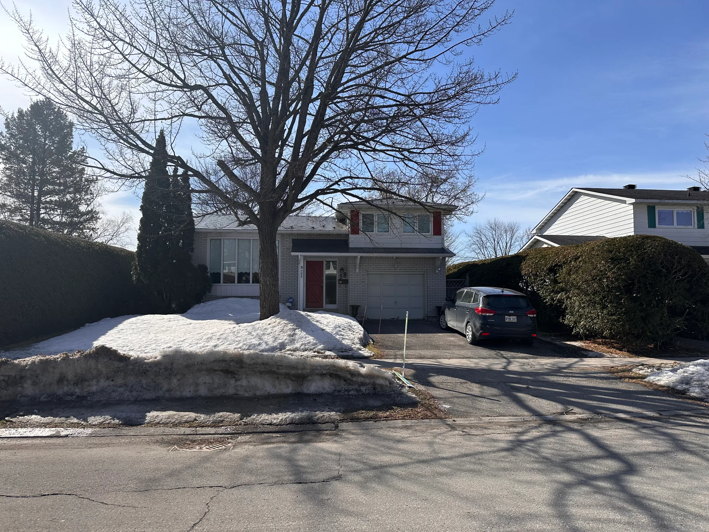 Charcoal Grey Interlock Shingle aluminum roof on a grey two-storey home with dormers in a snowy suburban, Ottawa, Ontario