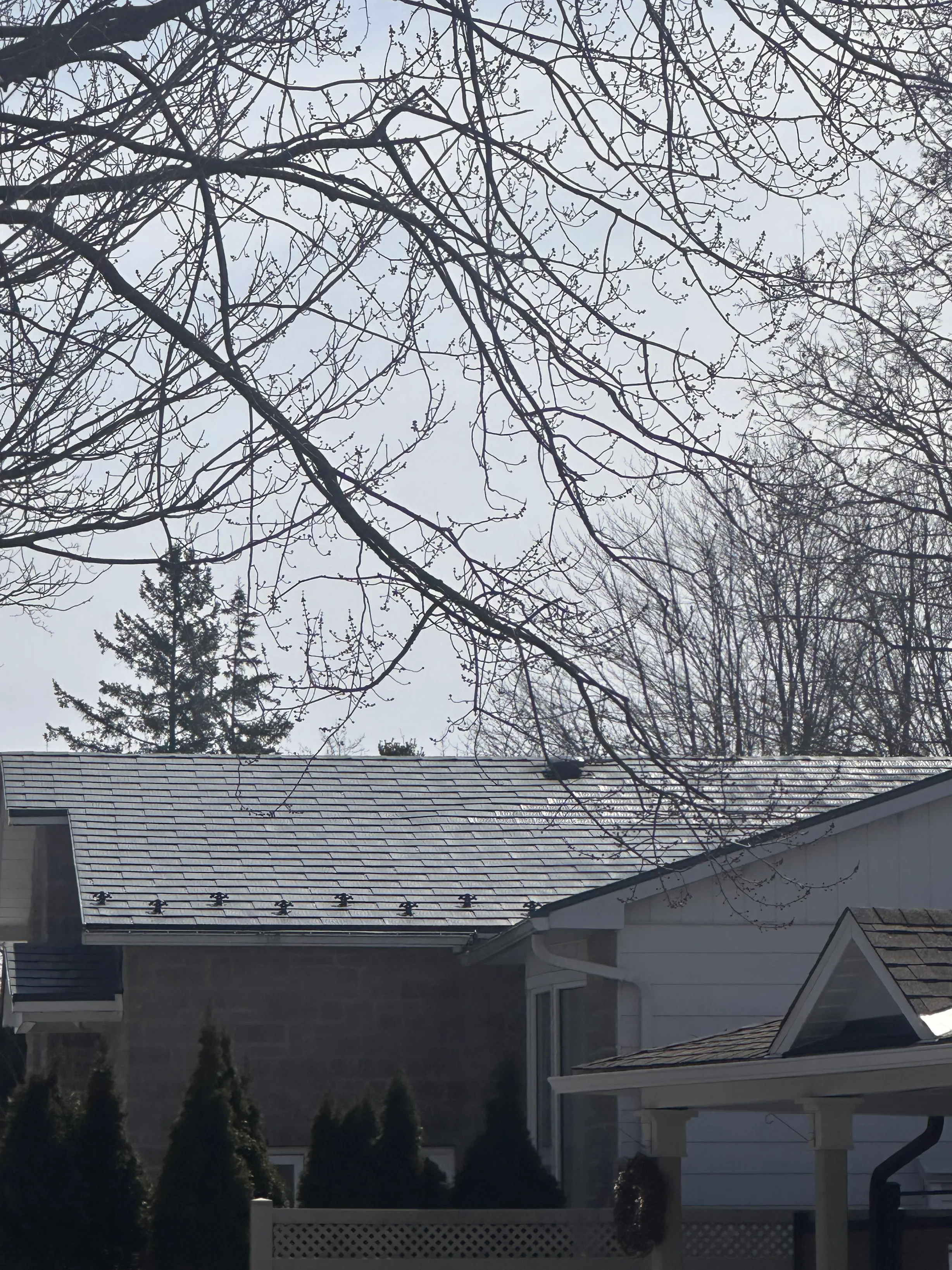 Charcoal Grey Interlock Shingle aluminum roof on a white single-family home with a gable roof in a suburban, Gloucester, Ontario