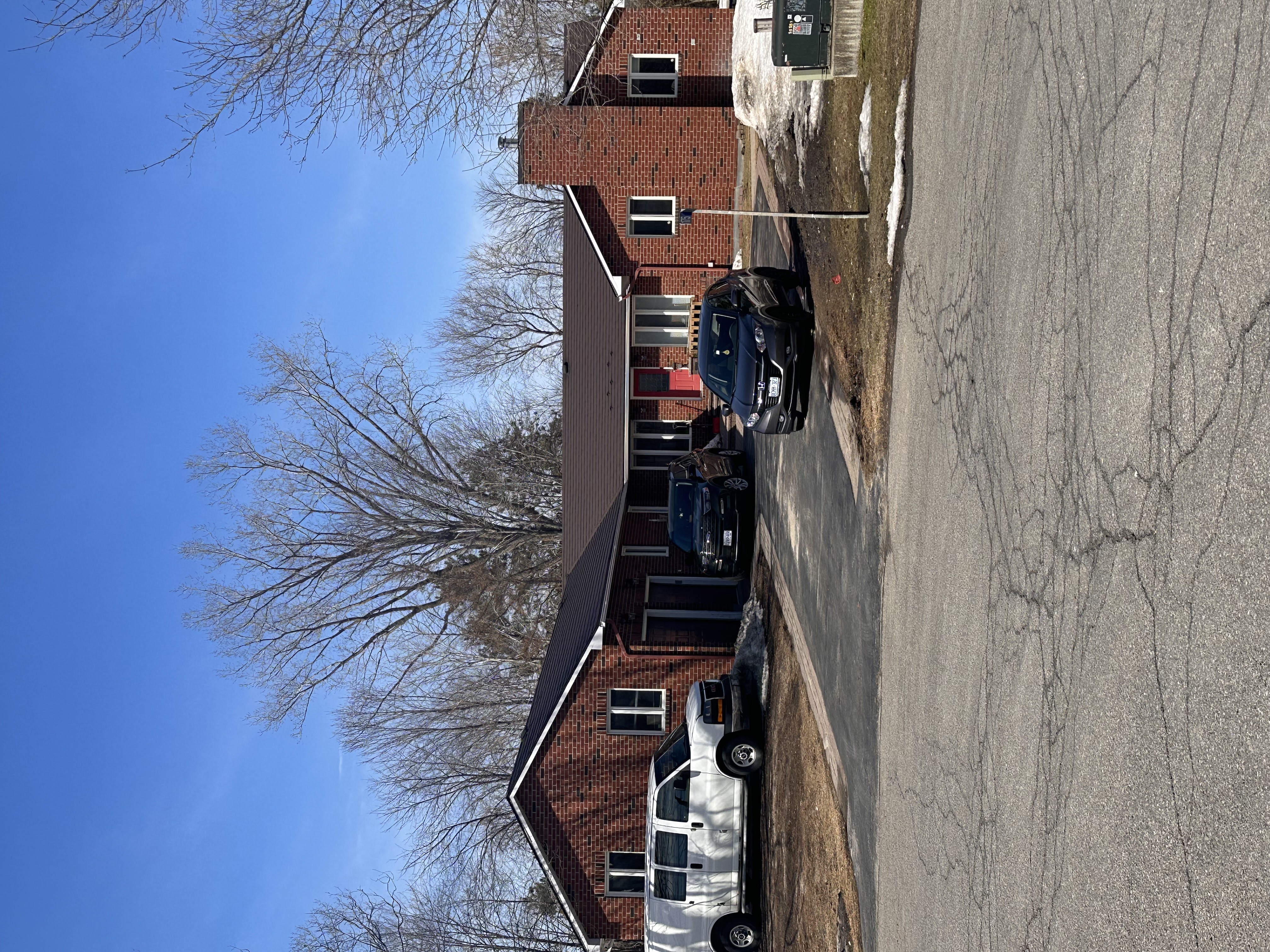 Front elevation of a single-storey red brick ranch home in Navan, ON featuring an Interlock Colonial Brown aluminum shingle roof with hip lines and prominent chimney.