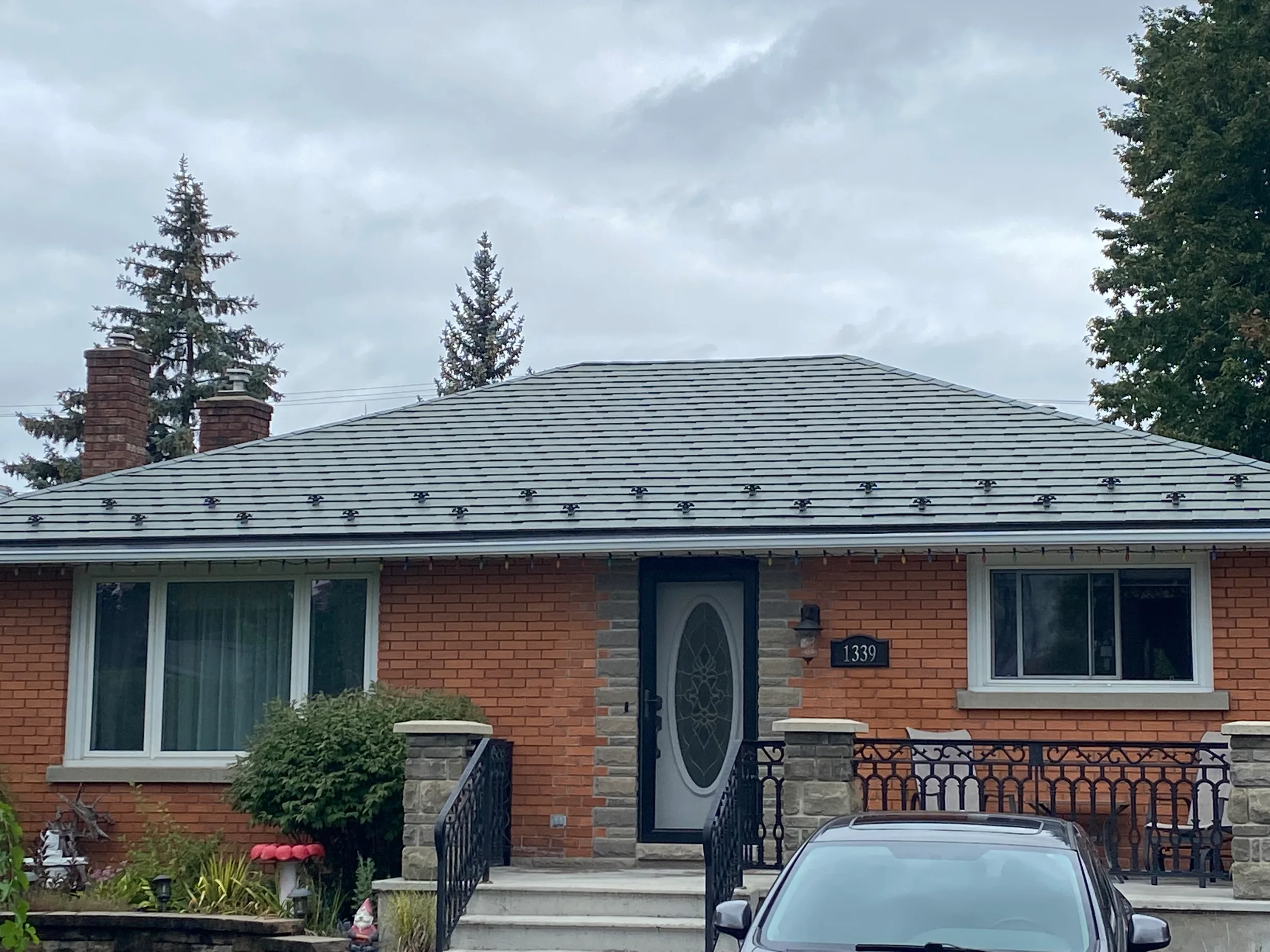 Hunter Green Interlock Slate aluminum roof on a red brick one-storey home with a metal roof, Ottawa, Ontario