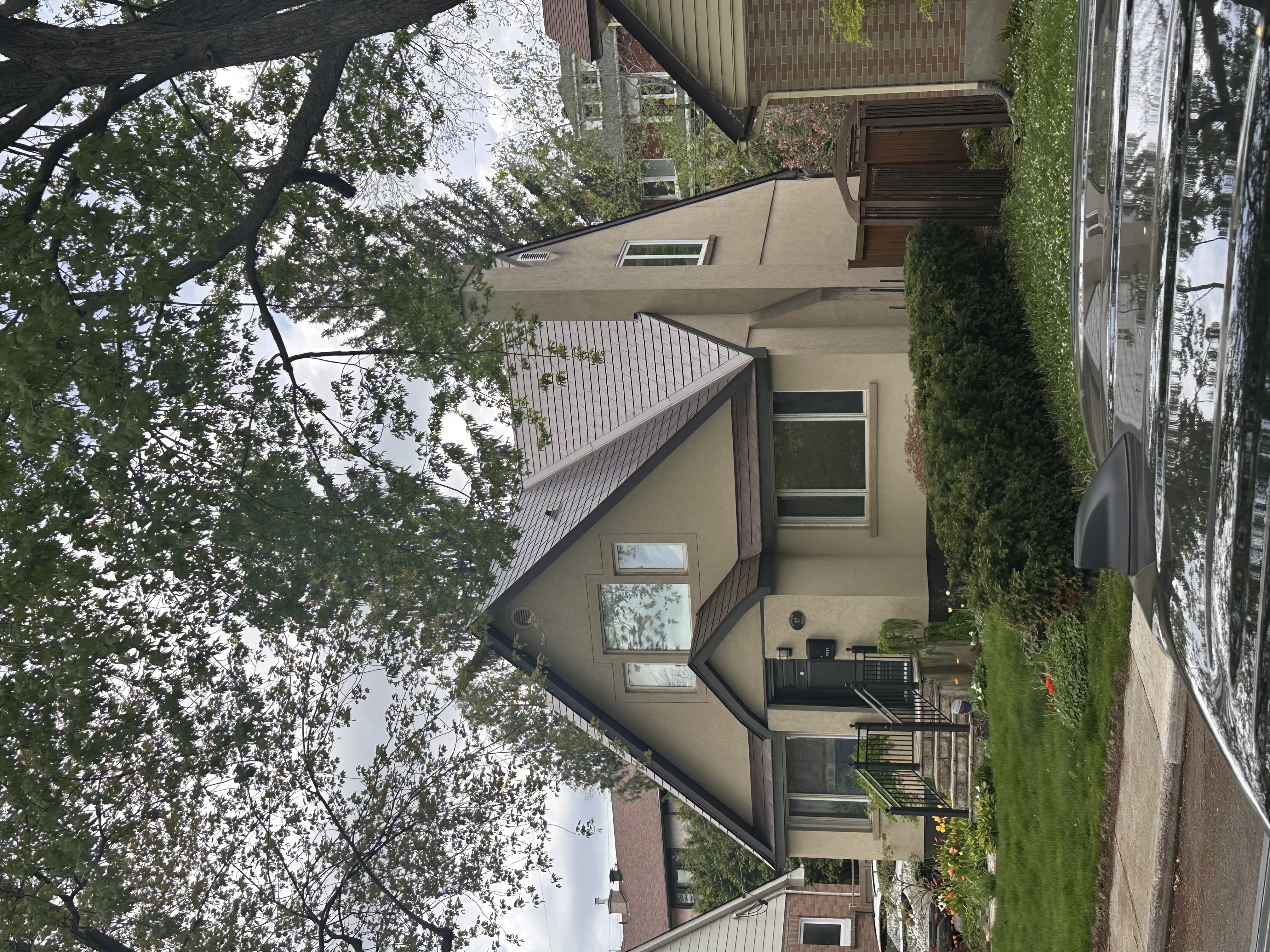 1.5-storey Tudor-style home in Ottawa with Interlock Colonial Brown aluminum slate metal roofing featuring steep complex gables and chimney.