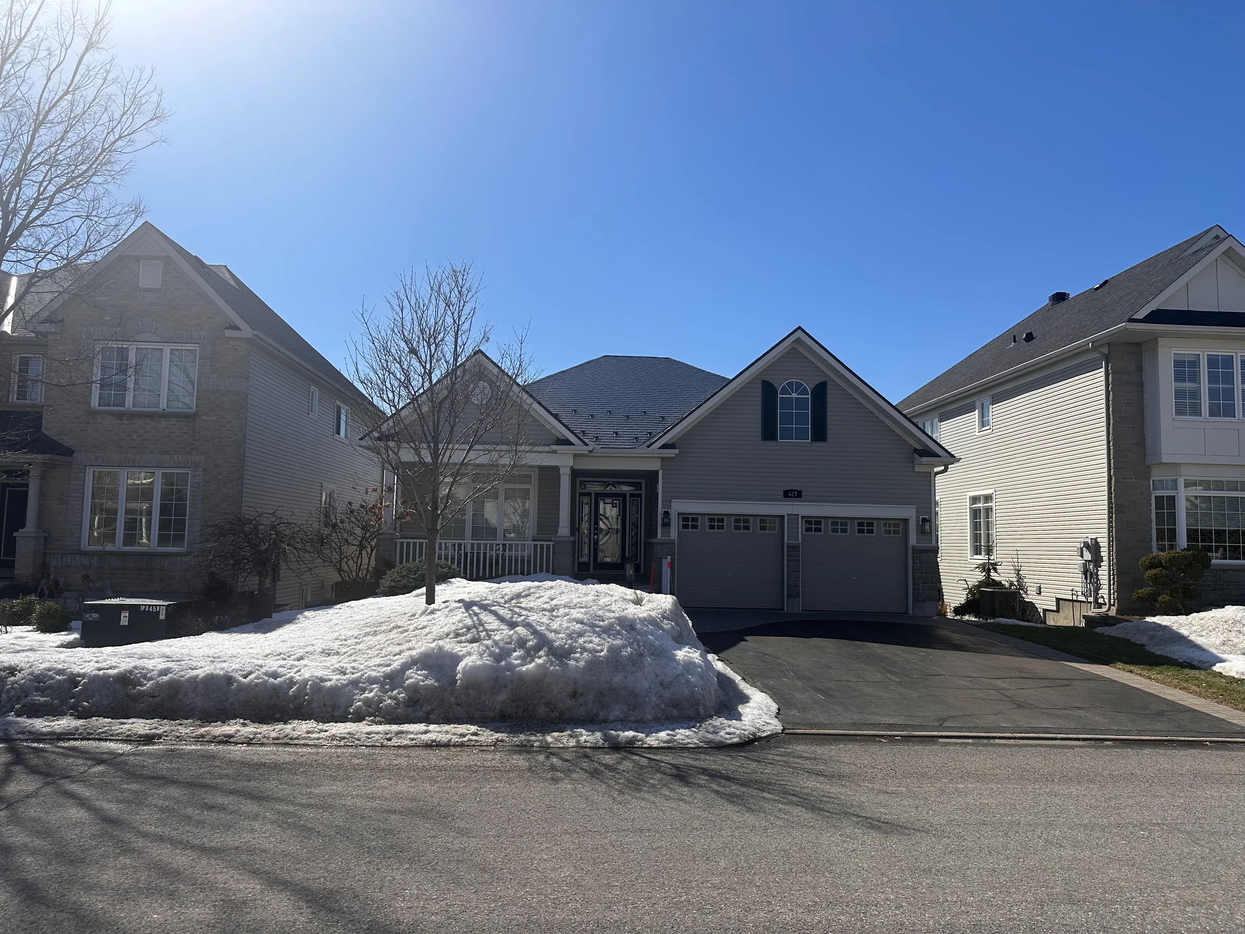 Black Interlock Slate aluminum roof on a beige single-family home with snow in a residential area, Ottawa, Ontario
