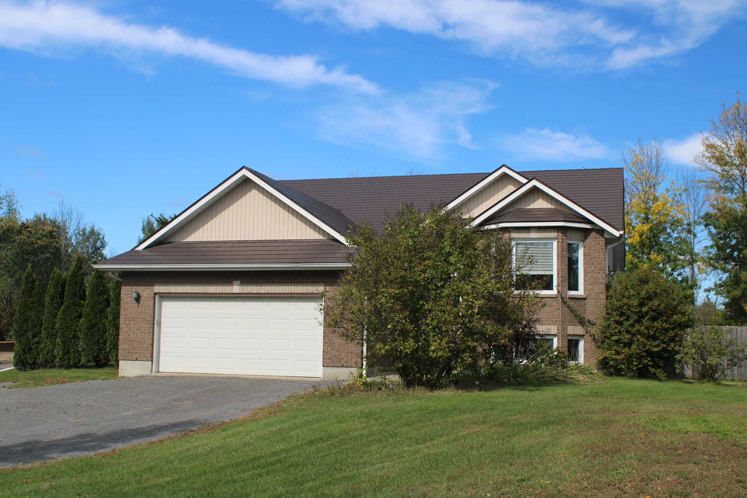 Tudor Brown Interlock Slate aluminum roof on a two-storey Tudor home with dormers in a suburban, Kingston, Ontario
