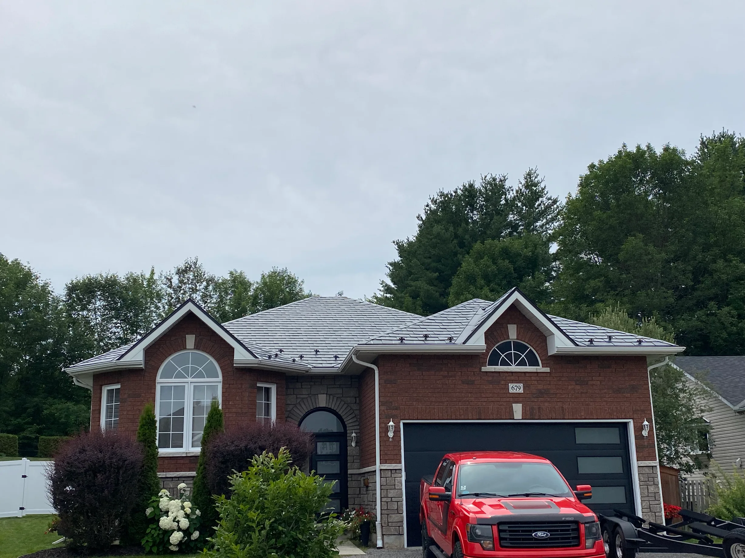 Black Interlock Slate aluminum roof on a red home with a metal roof in a wooded area, Pembroke, Ontario