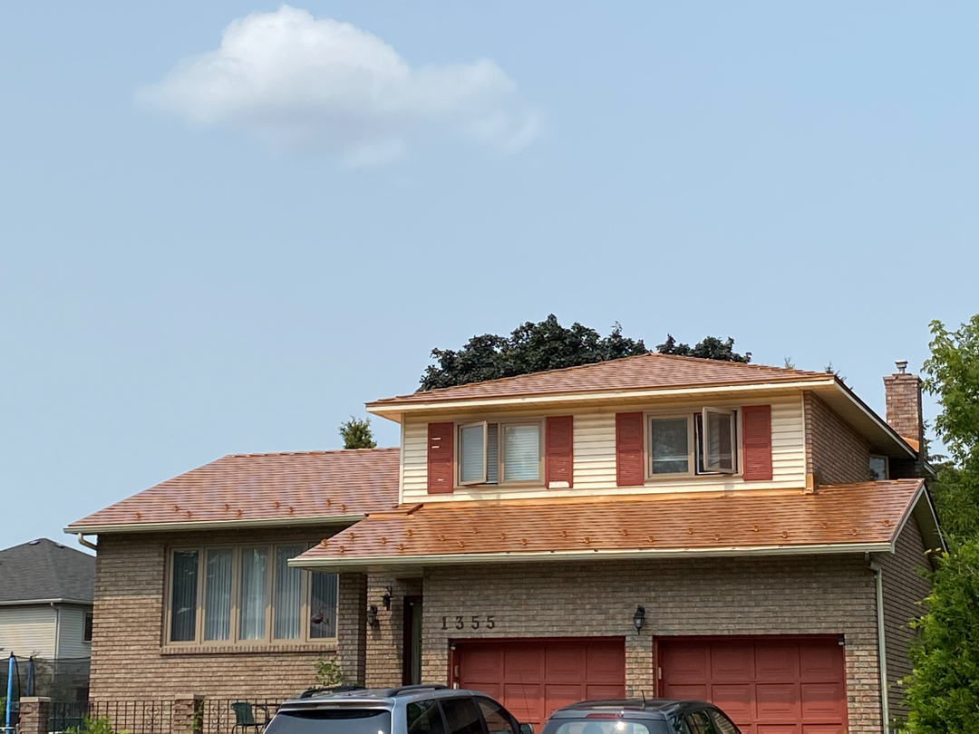Two-storey Colonial brick home at 1355 with Interlock Copper Penny aluminum slate metal roof, red shutters, and double garage in Gloucester, ON.
