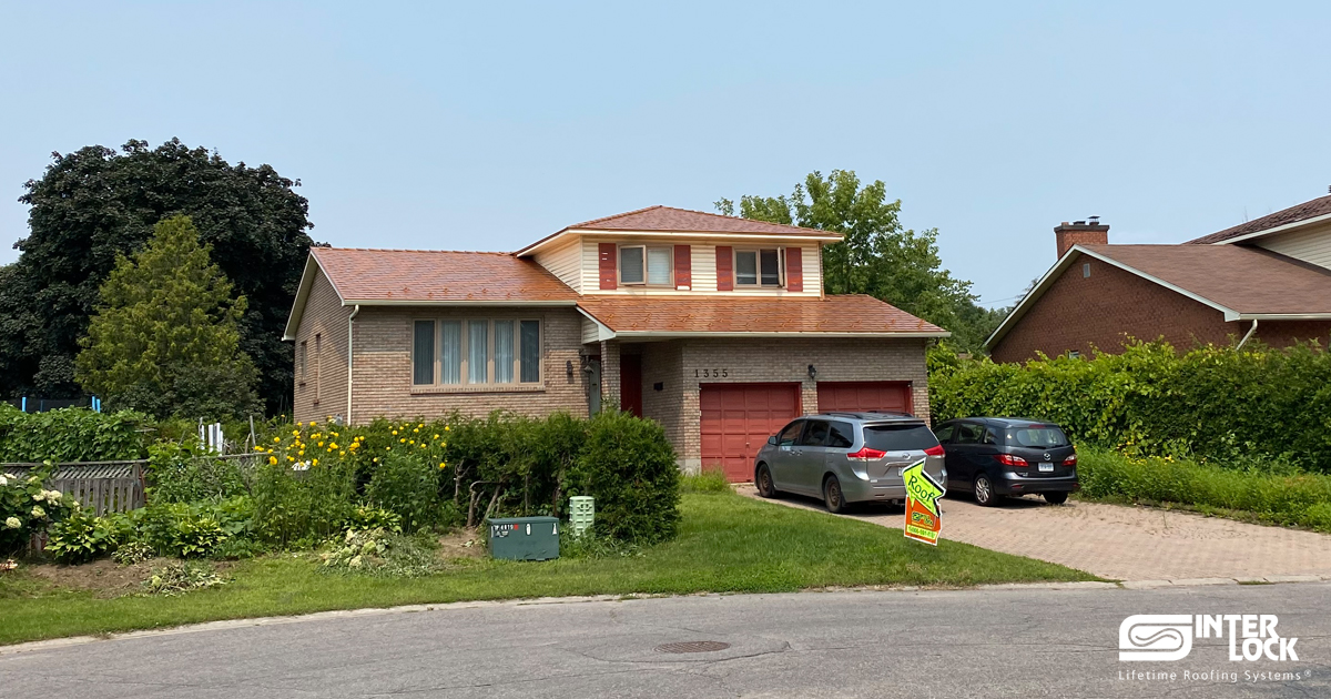 Two-storey brick Colonial home in Gloucester ON with Interlock Copper Penny aluminum slate metal roofing on a multi-hip roof.