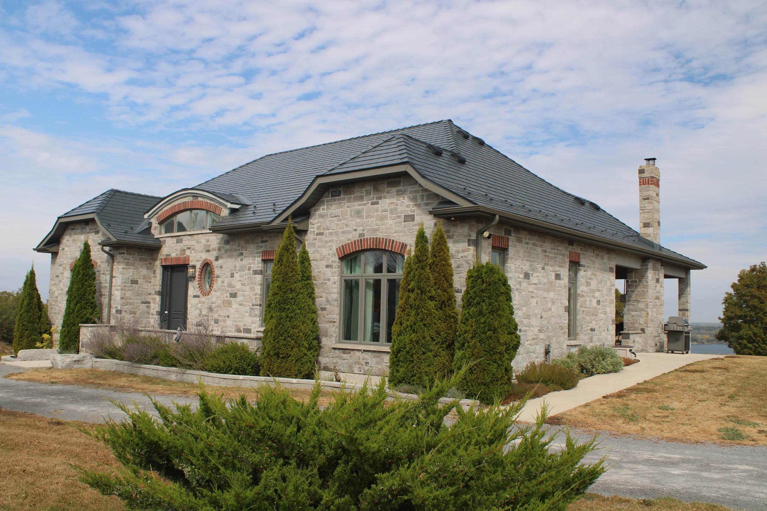 Deep Charcoal Interlock Slate aluminum roof on a colonial style house with a metal roof overlooking a lake, Picton, Ontario