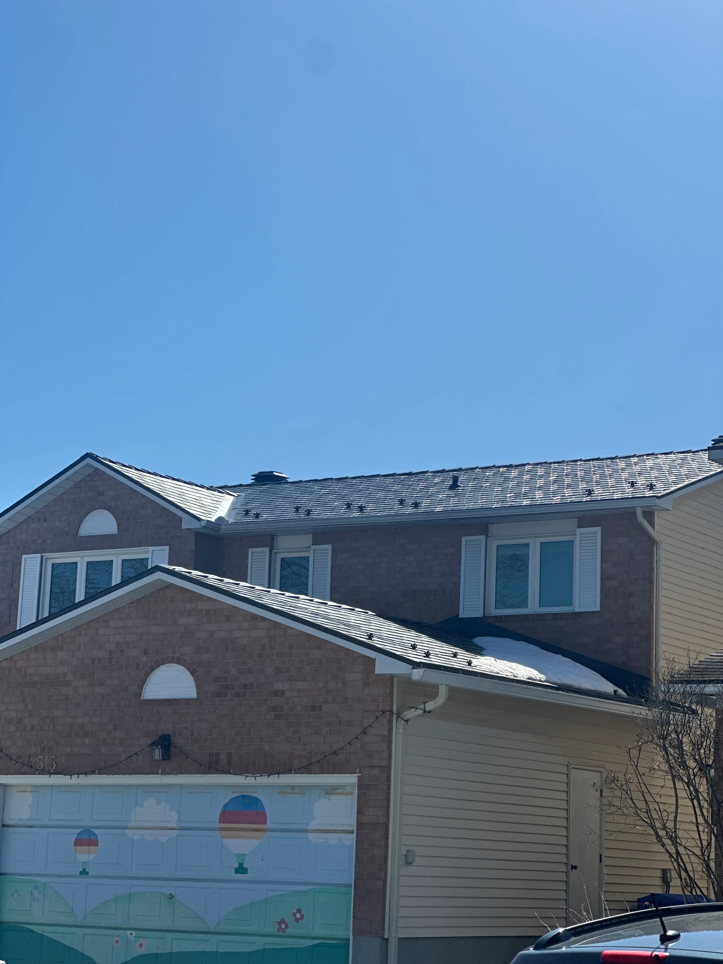 Black Interlock Slate aluminum roof on a brown two-storey home with dormers in a suburban setting, Orléans, Ontario