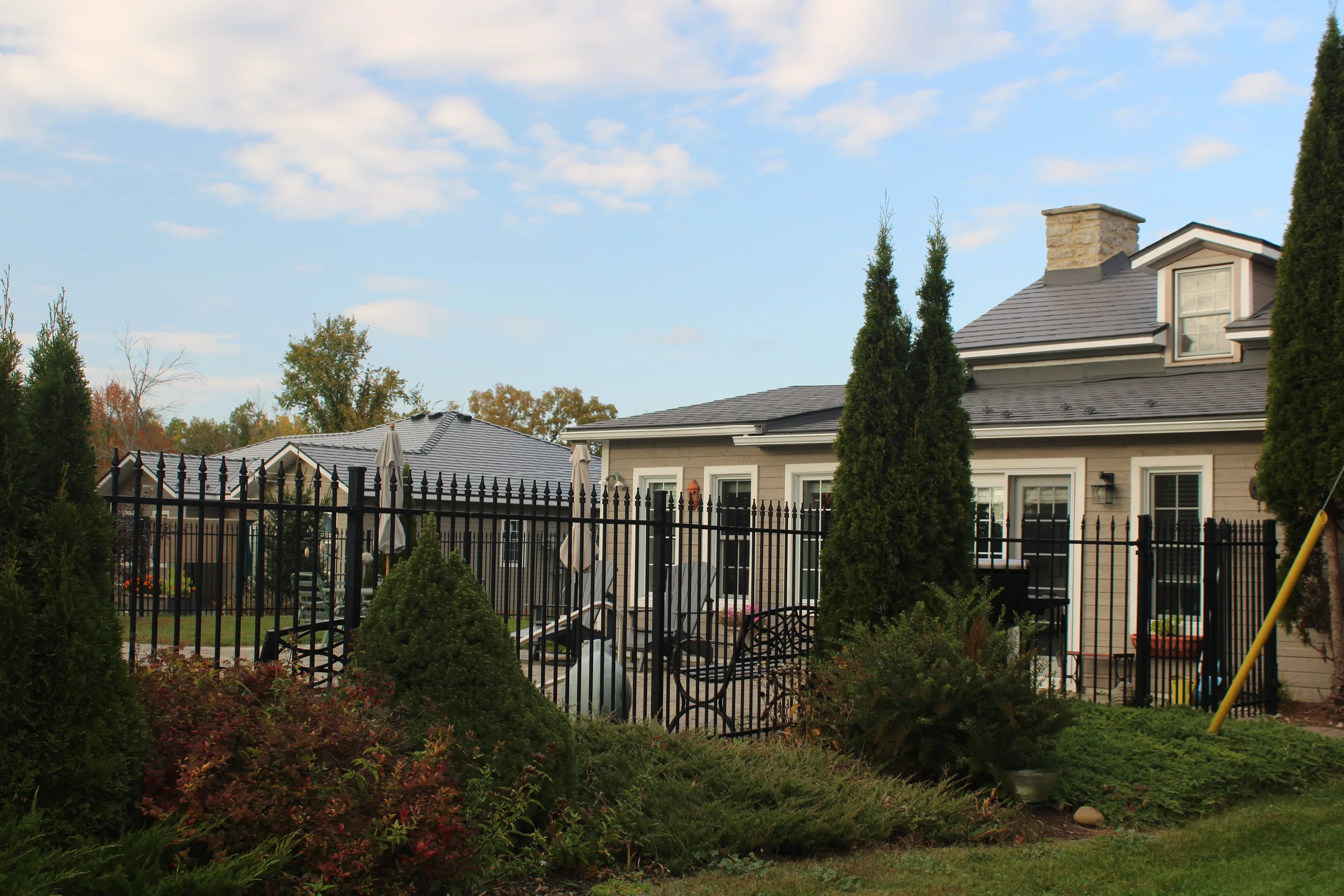 Deep Charcoal Interlock Slate aluminum roof on a tan home with a metal roof in a rural setting, Carleton Place, Ontario