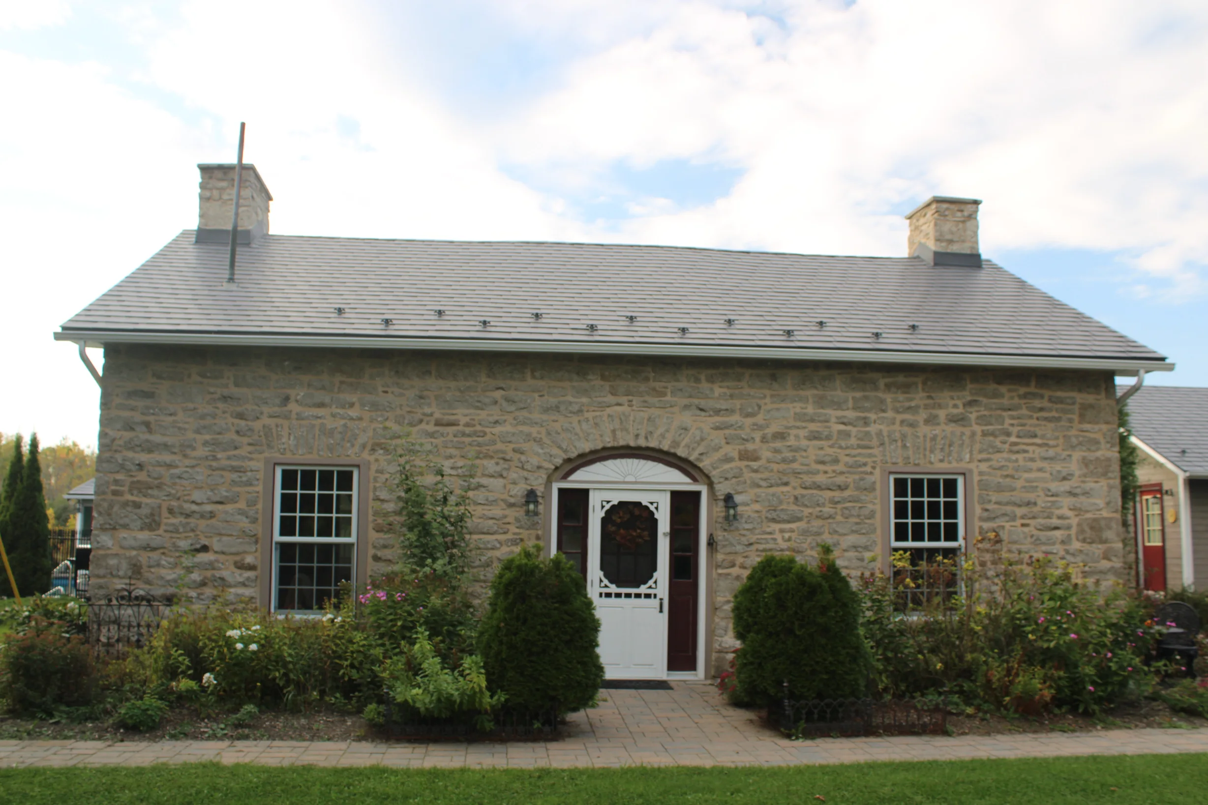 Deep Charcoal Interlock Slate aluminum roof on a brown single-storey cottage with dormers in a rural, Carleton Place, Ontario