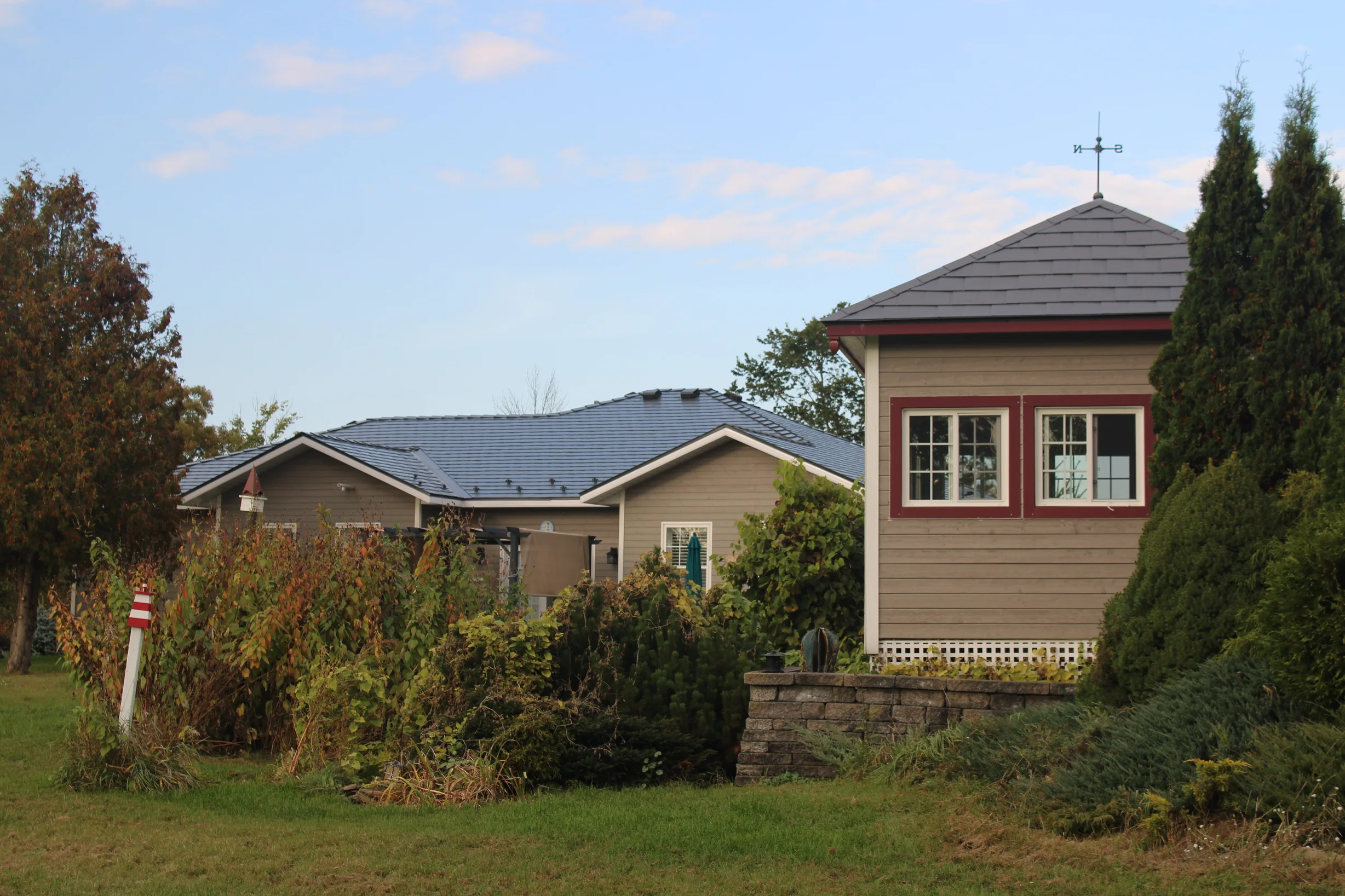 Deep Charcoal Interlock Slate aluminum roof on a tan house with a slate roof in a rural setting, Carleton Place, Ontario