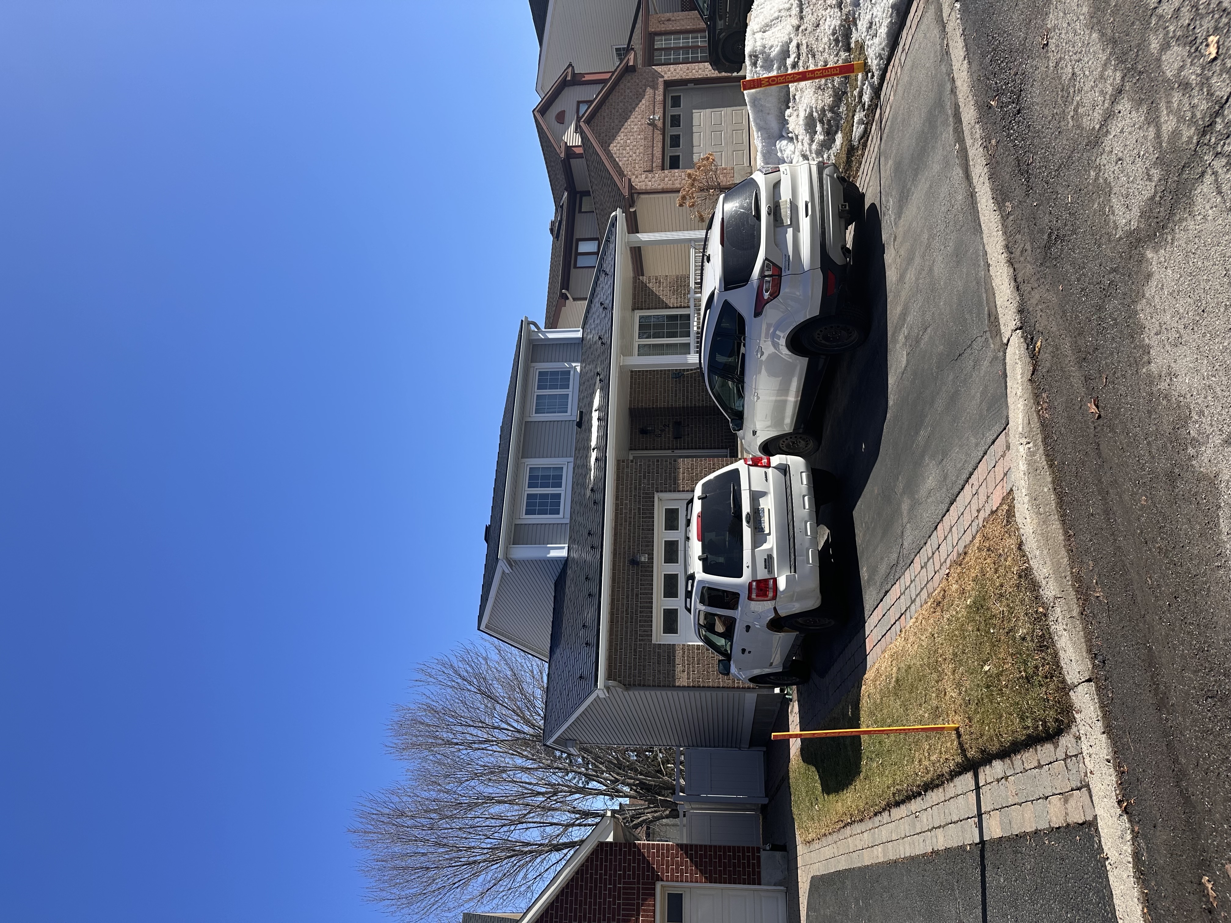 Two-storey brick Colonial home in Orleans ON fitted with black Interlock aluminum slate metal roofing, featuring a front dormer and attached garage.