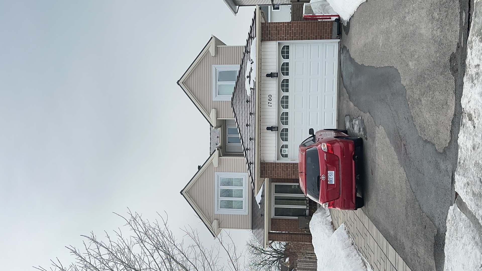 Two-storey colonial-style home in Ottawa with Interlock Colonial Brown aluminum slate metal roofing, twin dormers, and brick facade, photographed in winter.