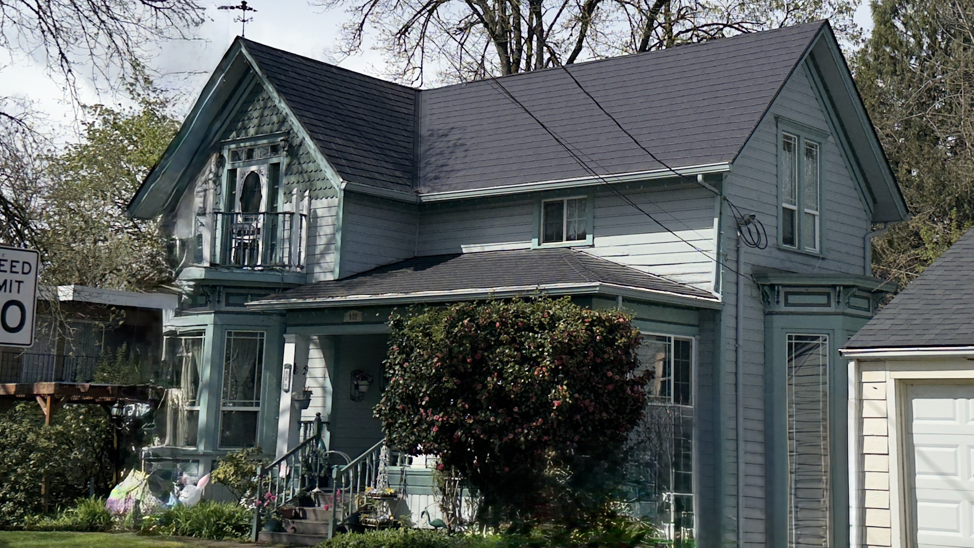 Victorian two-story home in Eugene OR with a complex black Interlock aluminum slate metal roof featuring a decorative front dormer and multiple roof planes.