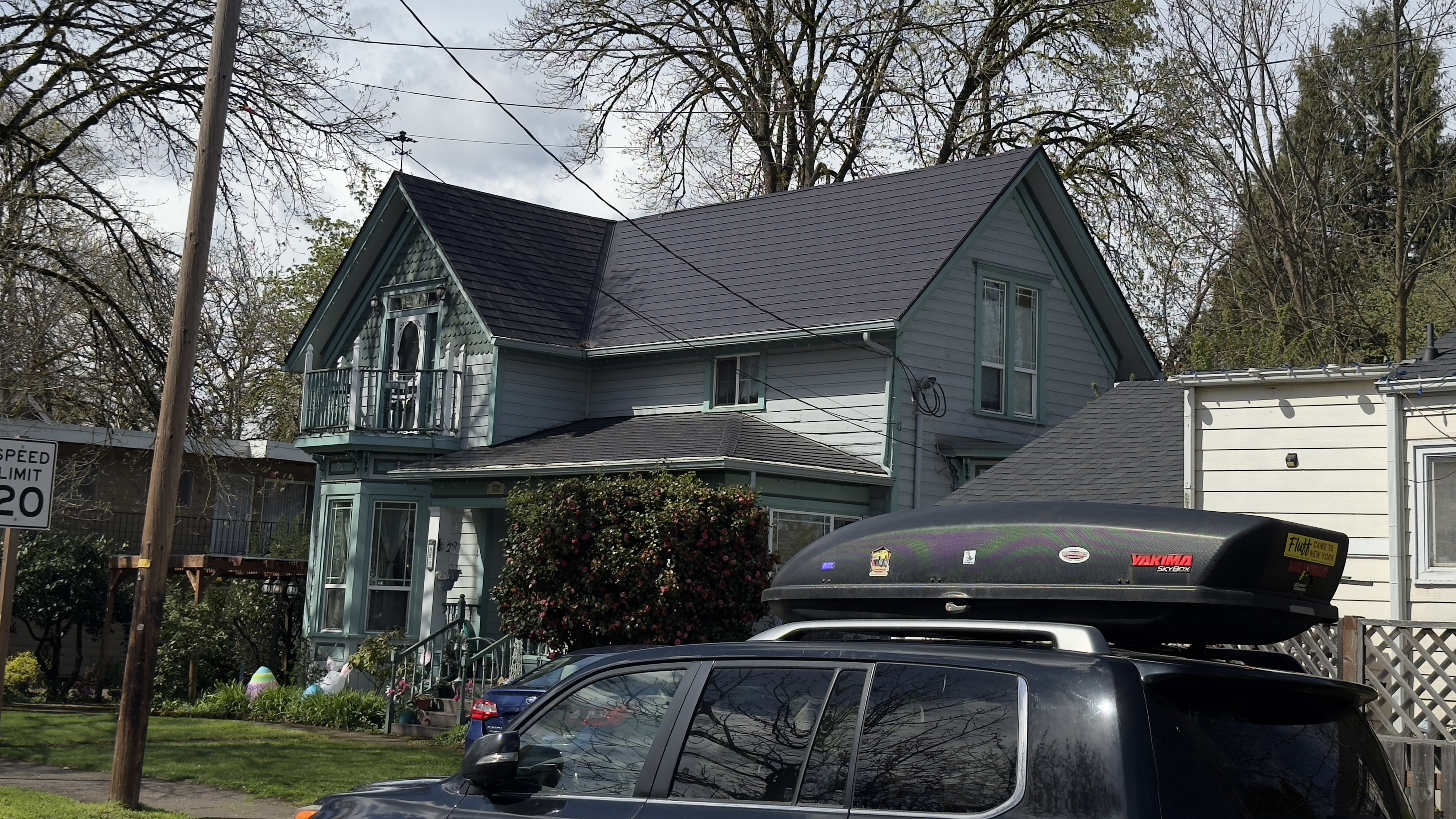 Victorian two-story home in Eugene OR with a steep multi-plane black Interlock aluminum slate metal roof featuring decorative gabled dormers.