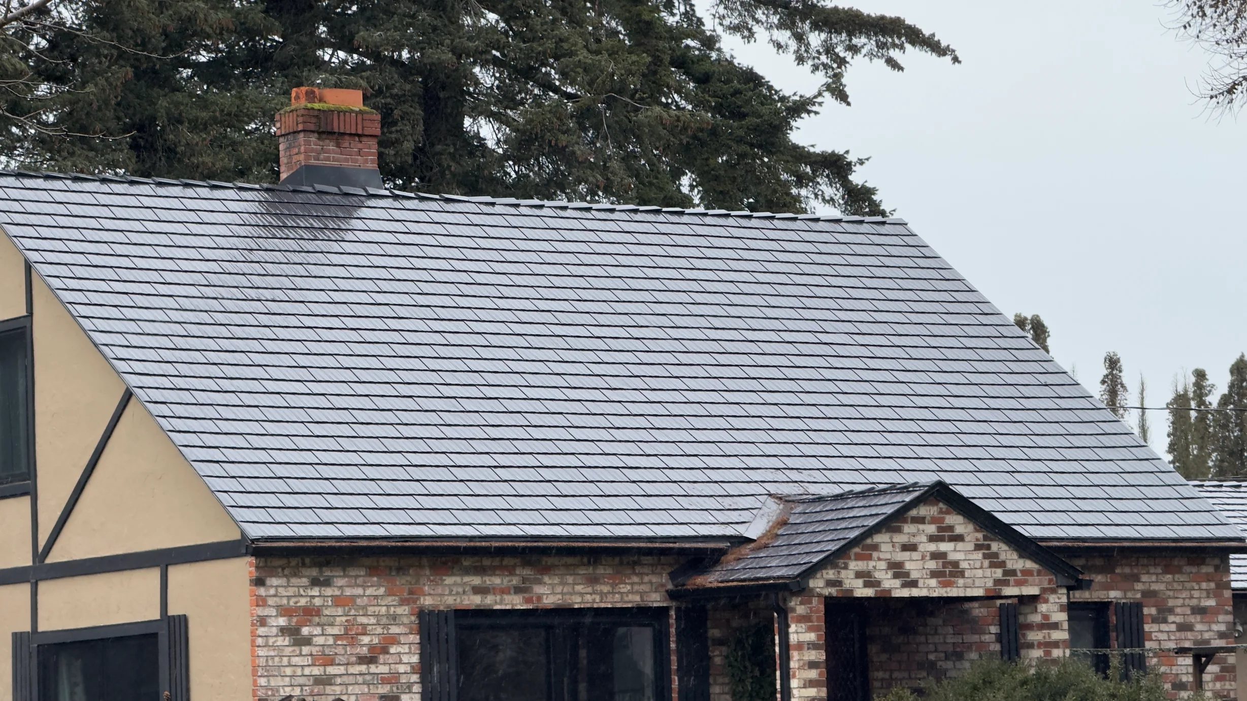 Black Interlock Cedar Shingle aluminum roof on a brown single-storey cottage with dormers in a forested, Hood River, Oregon