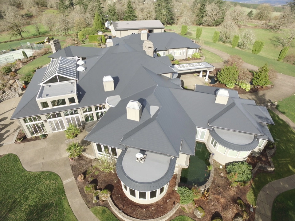 Deep Charcoal Interlock IB Membrane aluminum roof on a modern home with a grey metal roof in a forested rural, Turner, Oregon