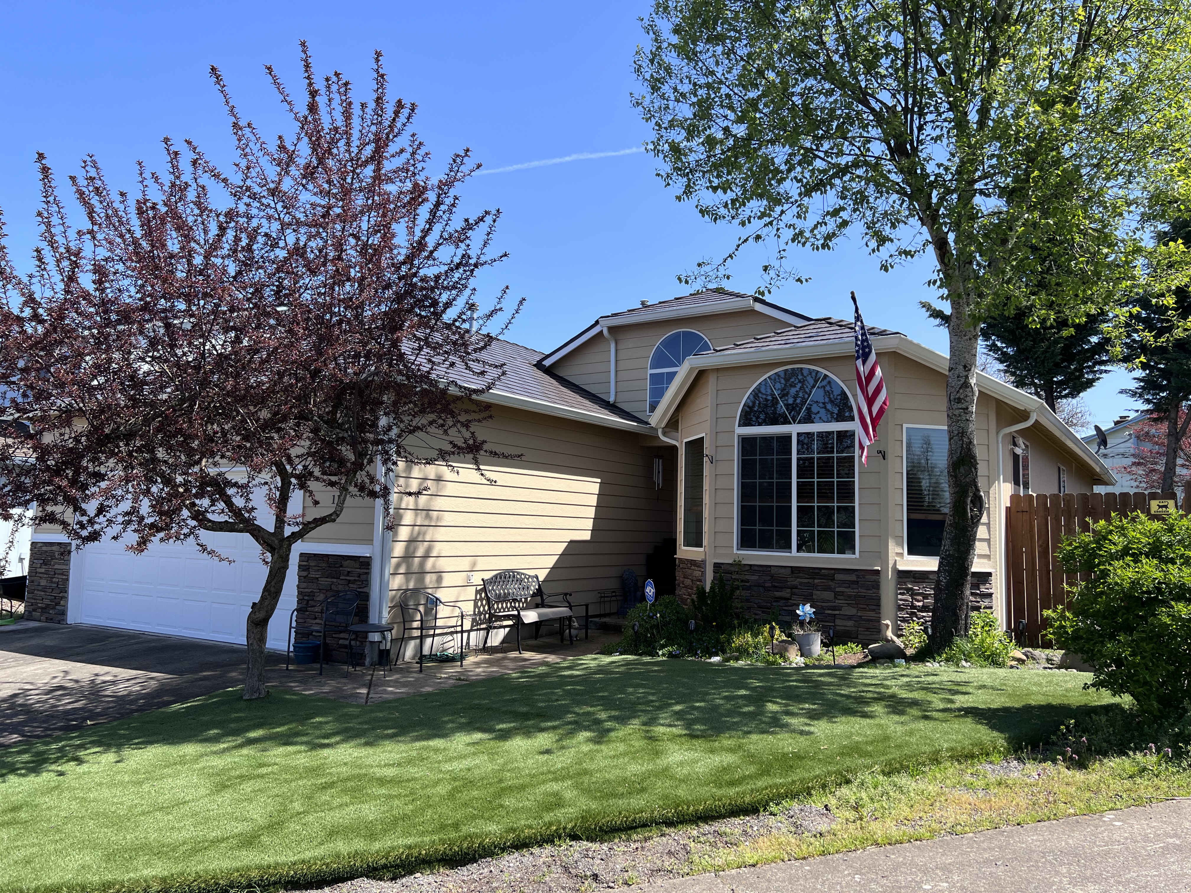 Front-left view of a 1.5-story ranch home in Molalla OR with Interlock Tudor Brown cedar shingle aluminum roofing over a multi-hip profile.