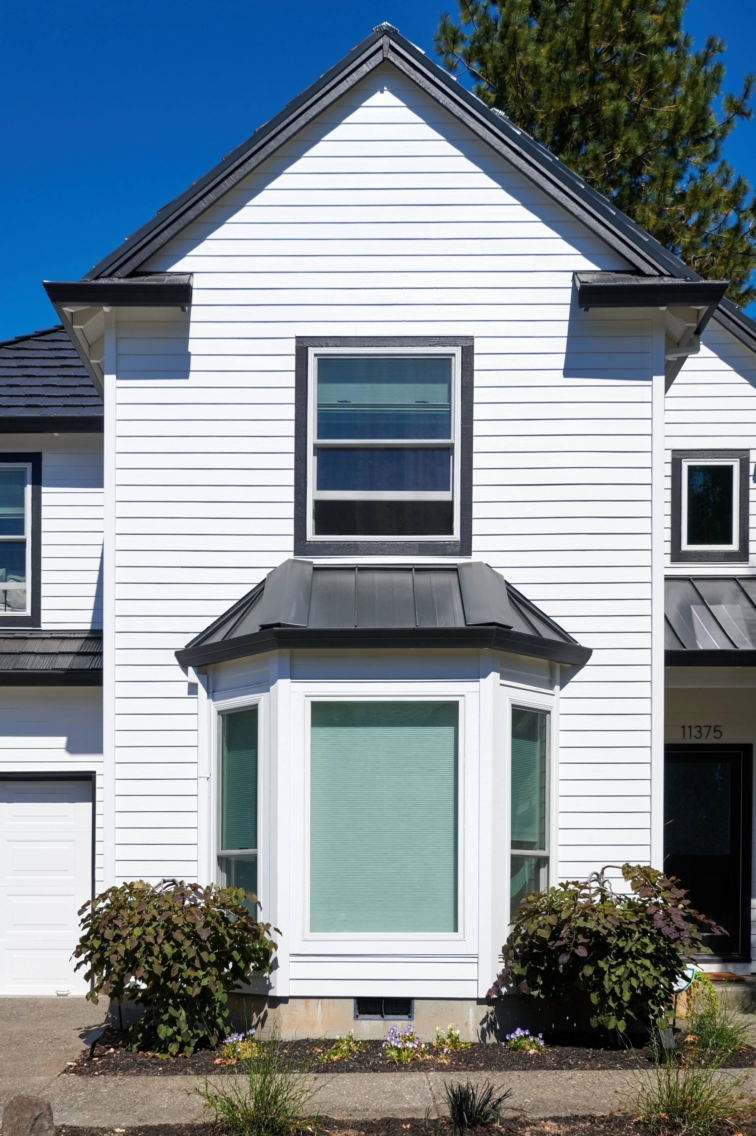 Deep Charcoal Interlock Shake aluminum roof on a white modern house with a metal roof in a suburban, Portland, Oregon