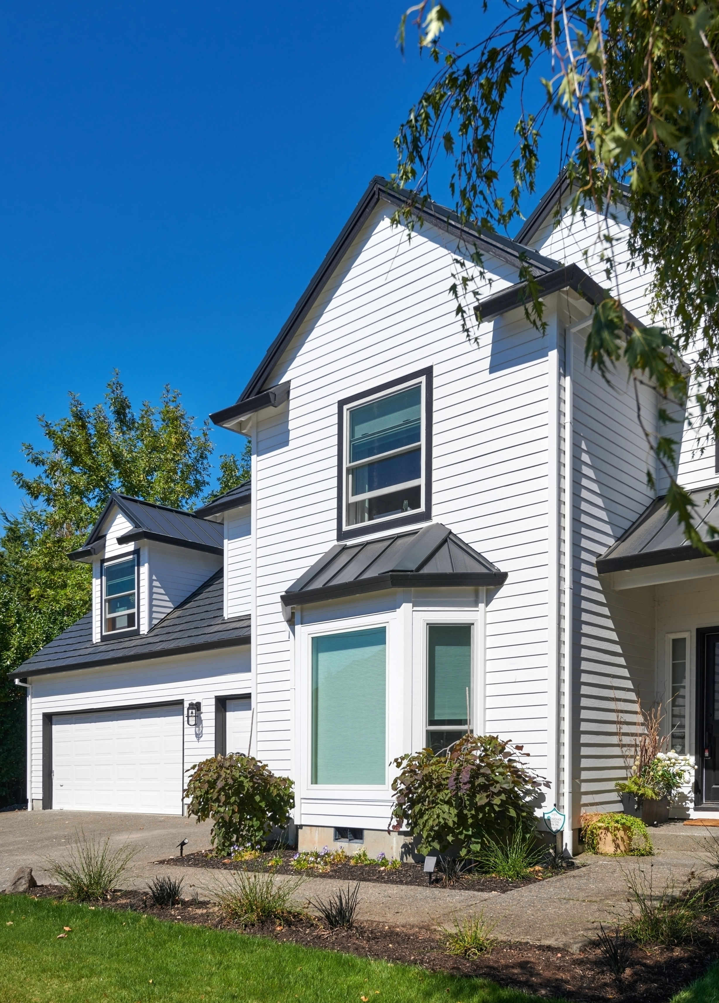 Deep Charcoal Interlock Shake aluminum roof on a white two-storey home with a metal roof in an urban, Portland, Oregon