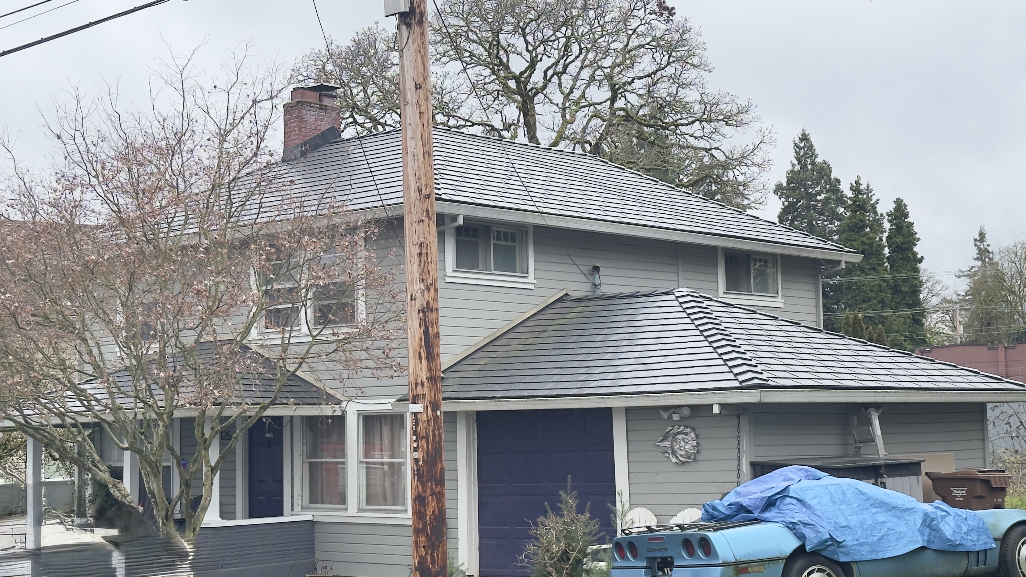 Two-story colonial home in St. Helens OR featuring a new black Interlock aluminum slate metal roof with multi-hip complexity and brick chimney.