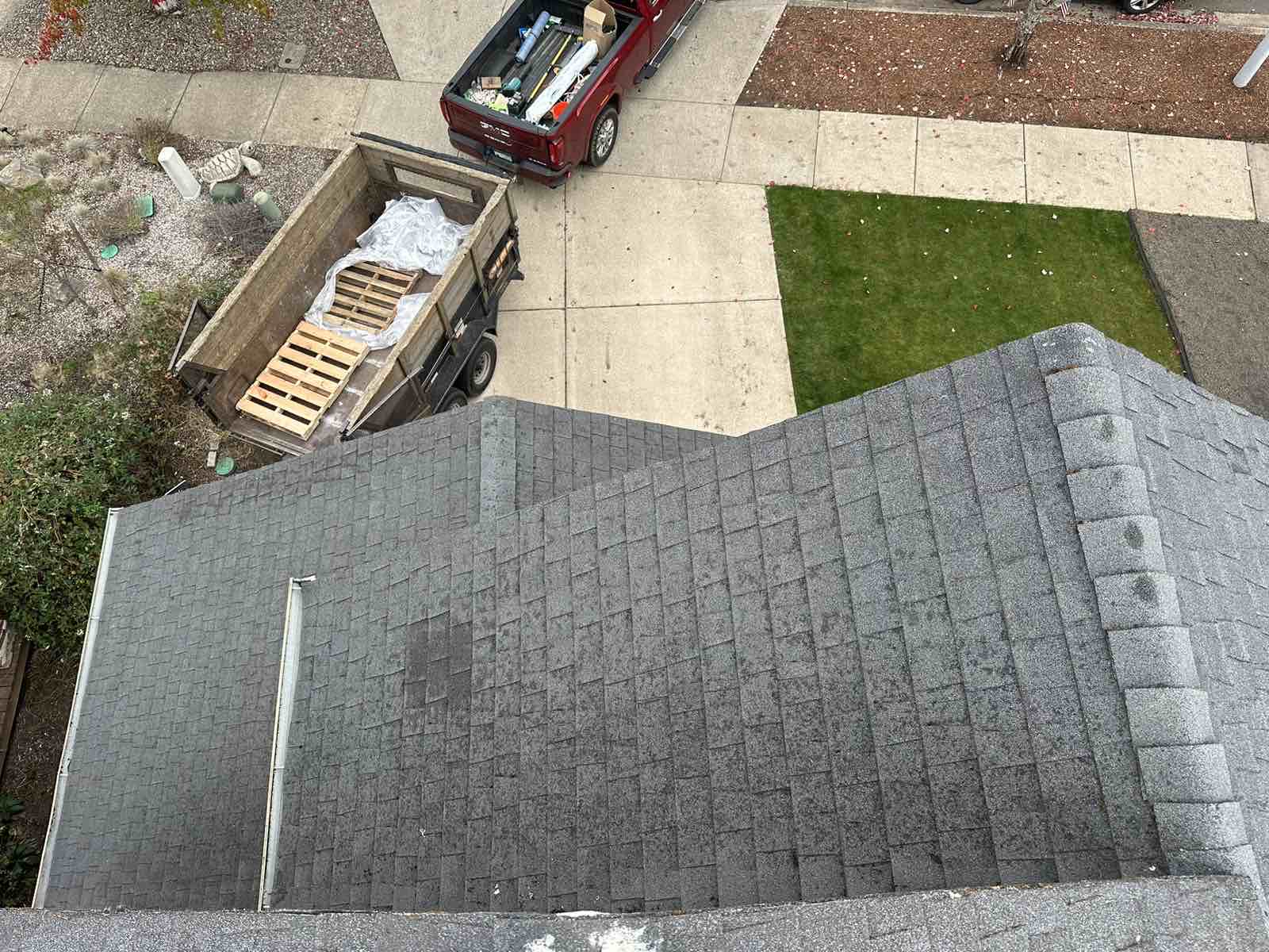 Aerial view of a deep charcoal Interlock aluminum cedar shingle metal roof on a suburban single-family home, showing a multi-plane layout with a valley.