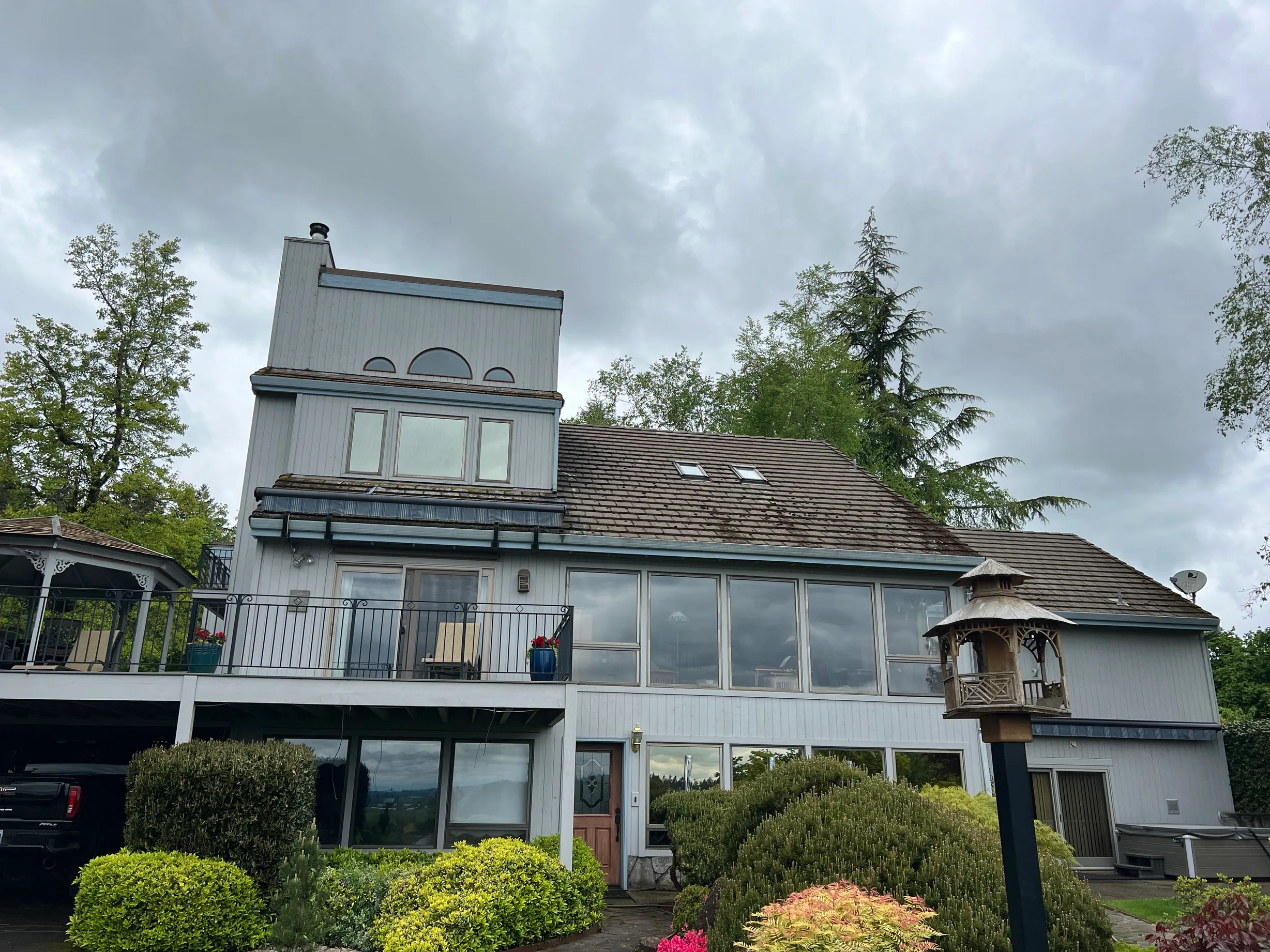Before: a concrete tile roof with broken tiles on the home, Amity, Oregon, ahead of a Deep Charcoal Interlock Slate aluminum roof