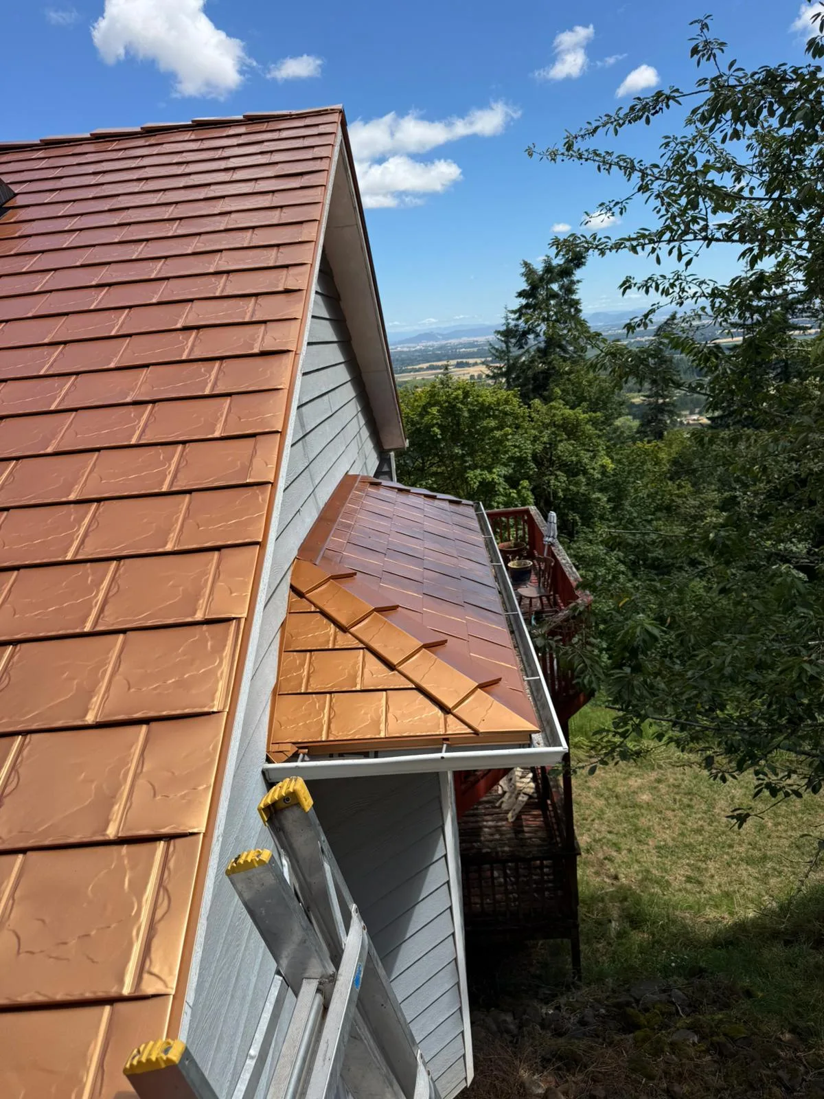 Copper Penny Interlock Slate aluminum roof on a two-storey home with a copper penny metal roof among tall, Corvallis, Oregon