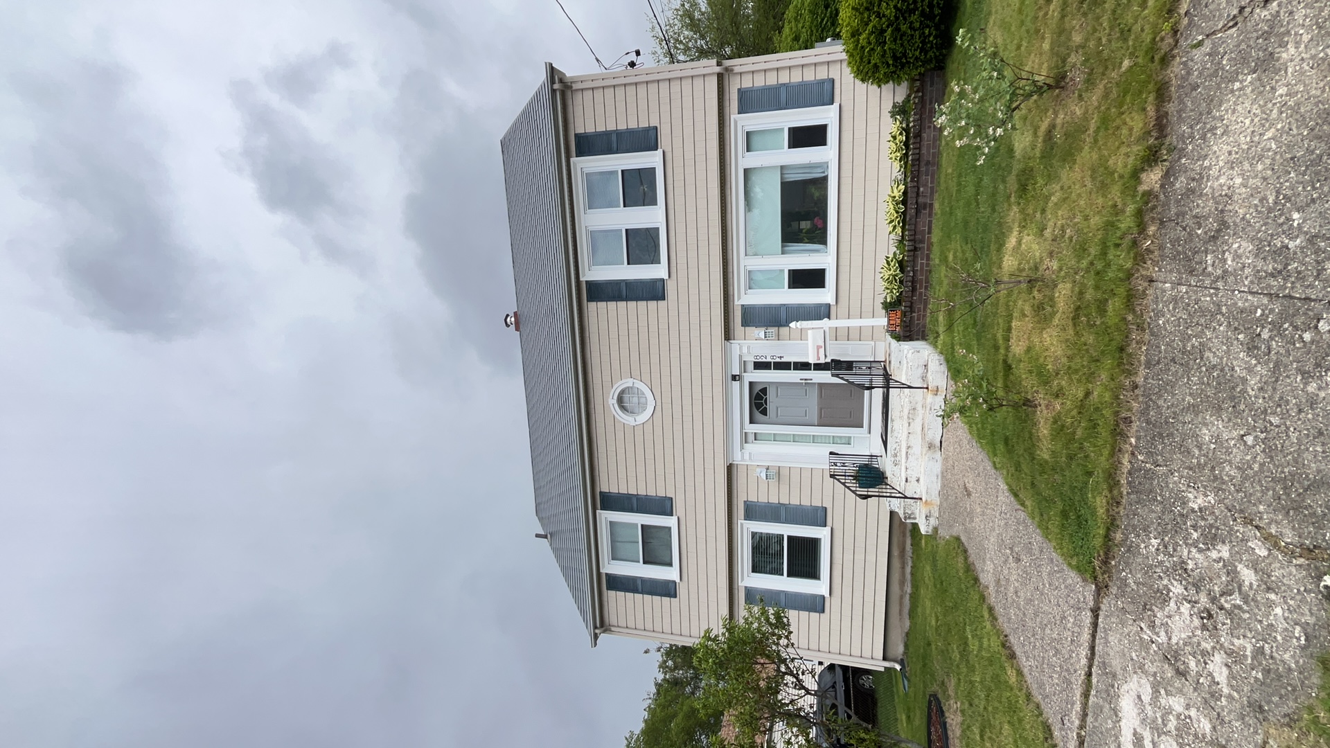 Two-story Colonial home in Pawtucket, RI with Interlock deep charcoal aluminum slate metal roof, dark shutters, and center entry door.