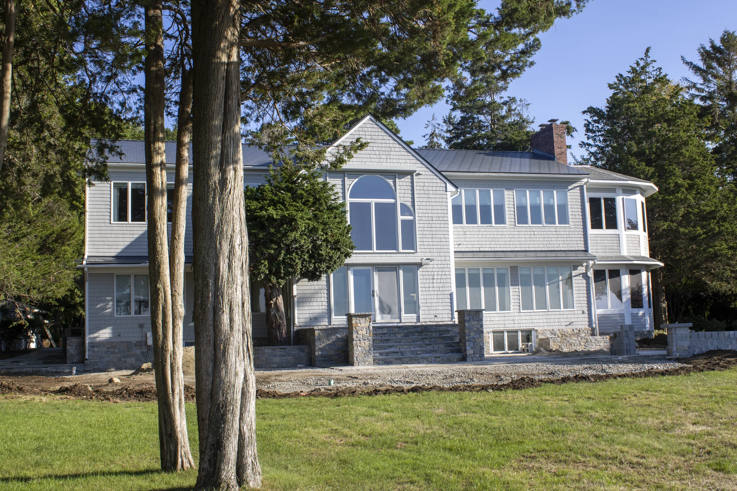 Deep Charcoal Interlock Slate aluminum roof on a white home with a metal roof in a wooded rural setting, Warwick, Rhode Island