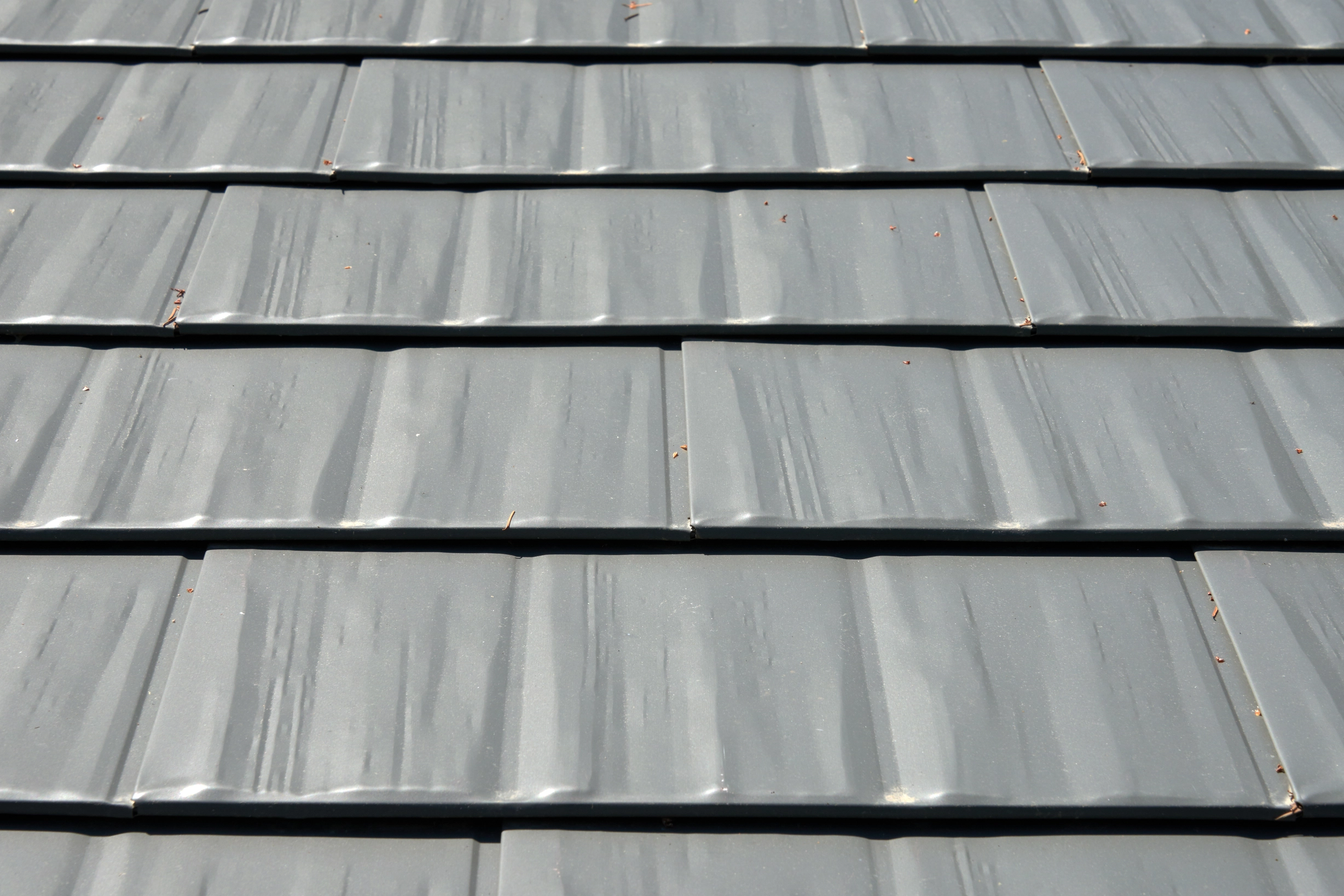 Musket Grey Interlock Cedar Shingle aluminum roof on a grey two-storey home with a modern metal roof among trees, Arlington, Washington