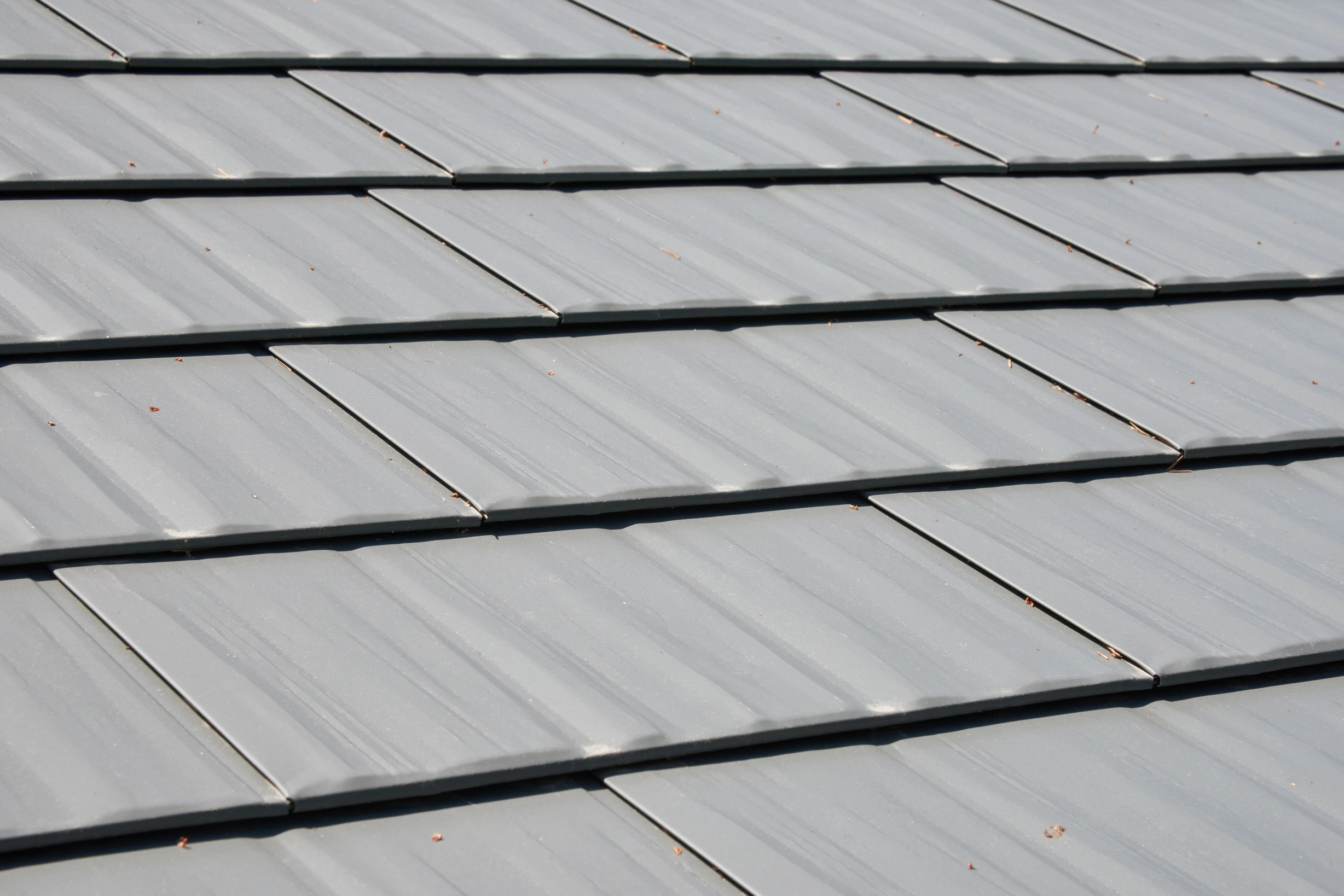 Musket Grey Interlock Cedar Shingle aluminum roof on a grey two-storey home with dormers and a metal roof in, Arlington, Washington