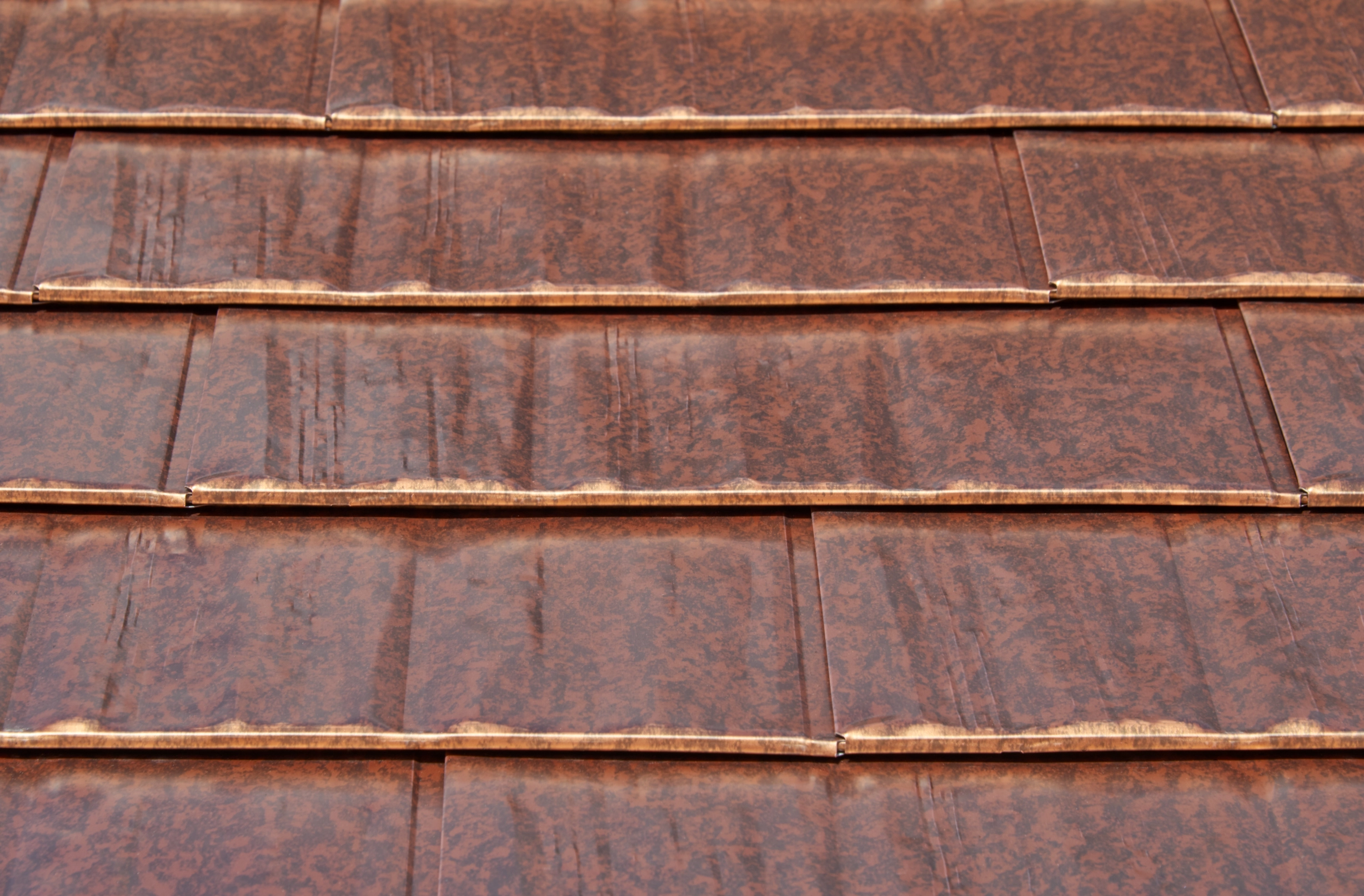Aged Copper Interlock Cedar Shingle aluminum roof on a brown two-storey home with a metal roof in a rural setting, Burien, Washington