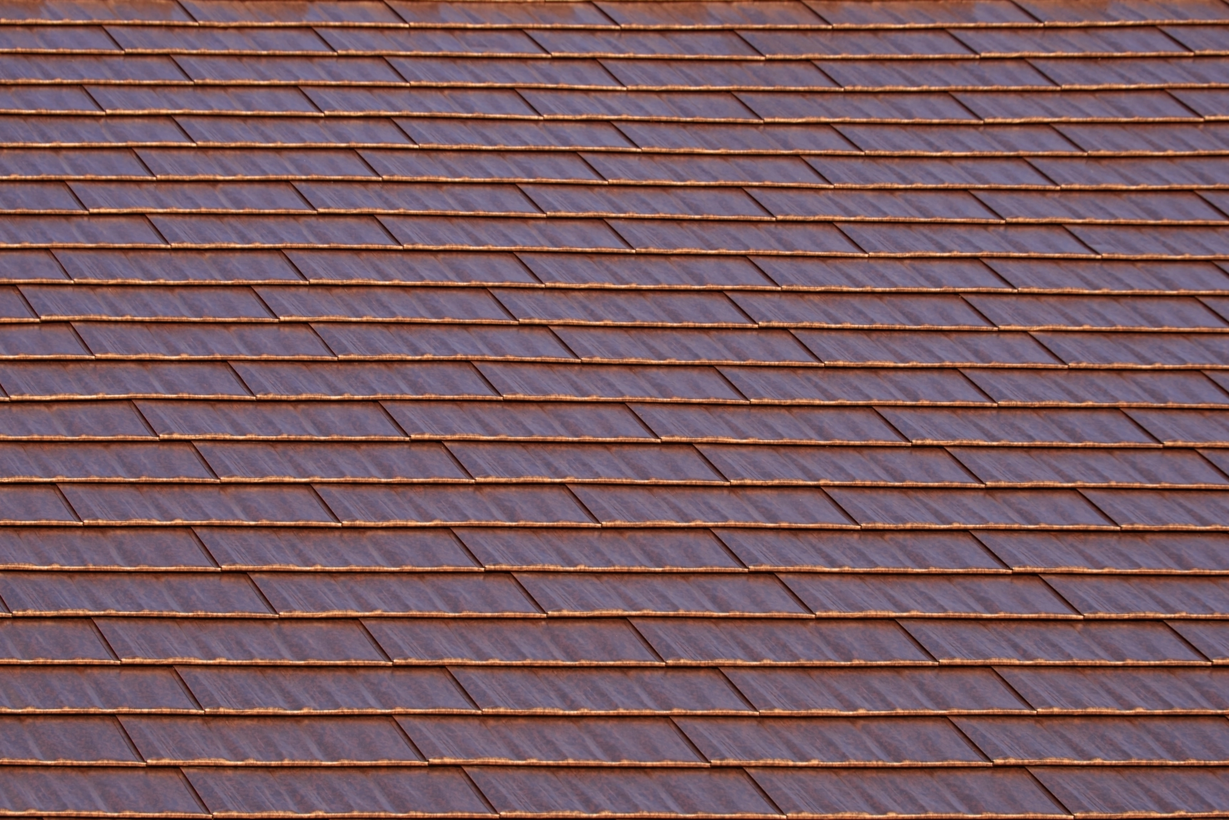 Aged Copper Interlock Cedar Shingle aluminum roof on a brown two-storey home with dormers in a suburban, Burien, Washington