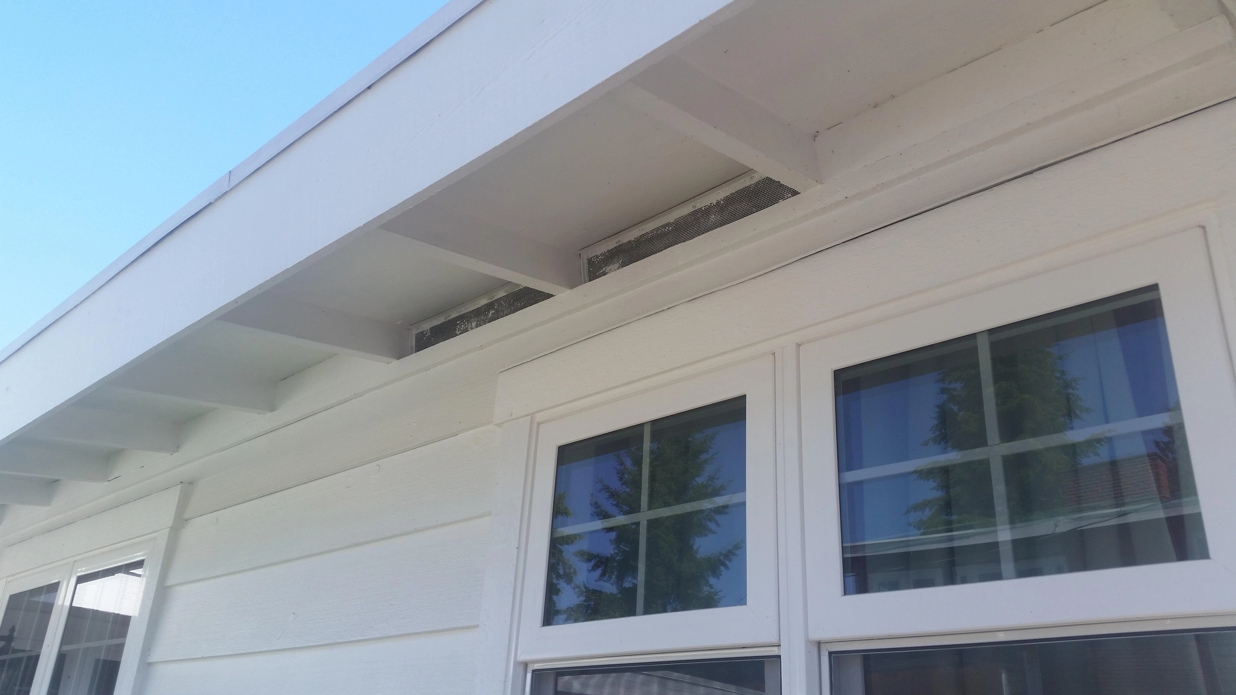Before: the old roof on a white one-storey home with a black metal roof in a, Des Moines, Washington, ahead of a Black Interlock Standing Seam aluminum roof