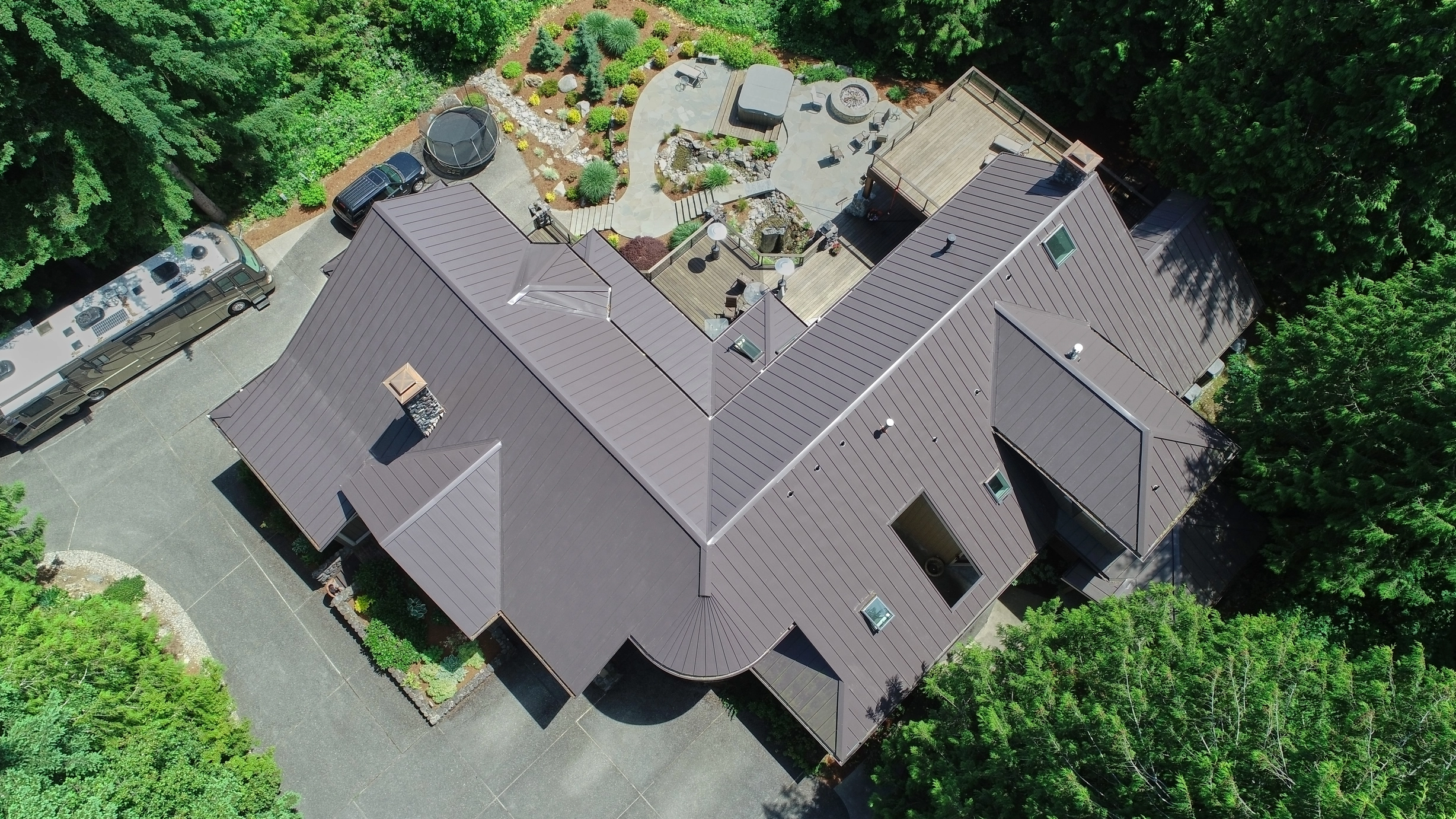 Tudor Brown Interlock Standing Seam aluminum roof on a Tudor Brown metal roof on a colonial home among tall trees, Fall City, Washington