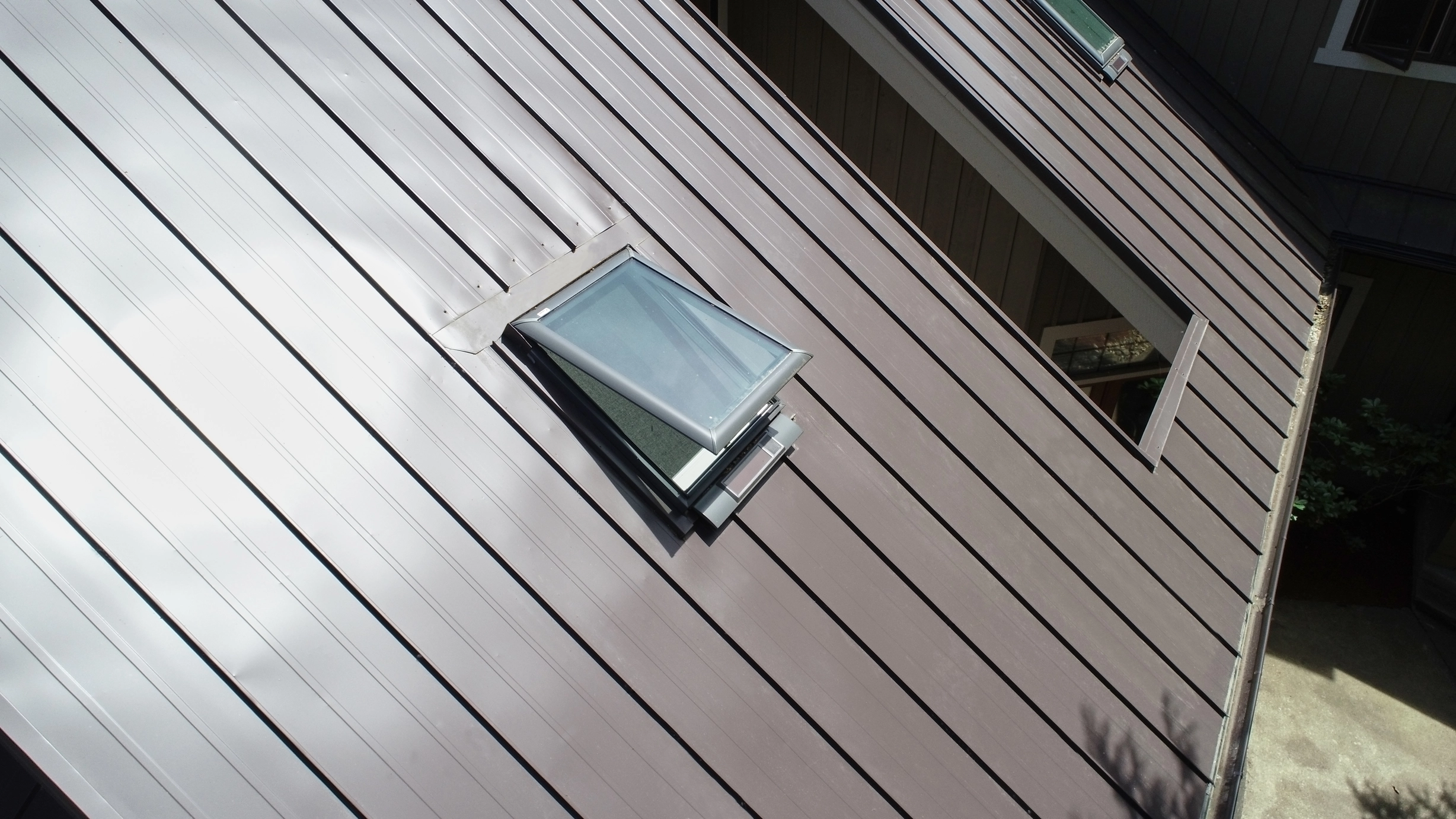 Tudor Brown Interlock Standing Seam aluminum roof on a brown home with a brown metal roof among tall trees, Fall City, Washington